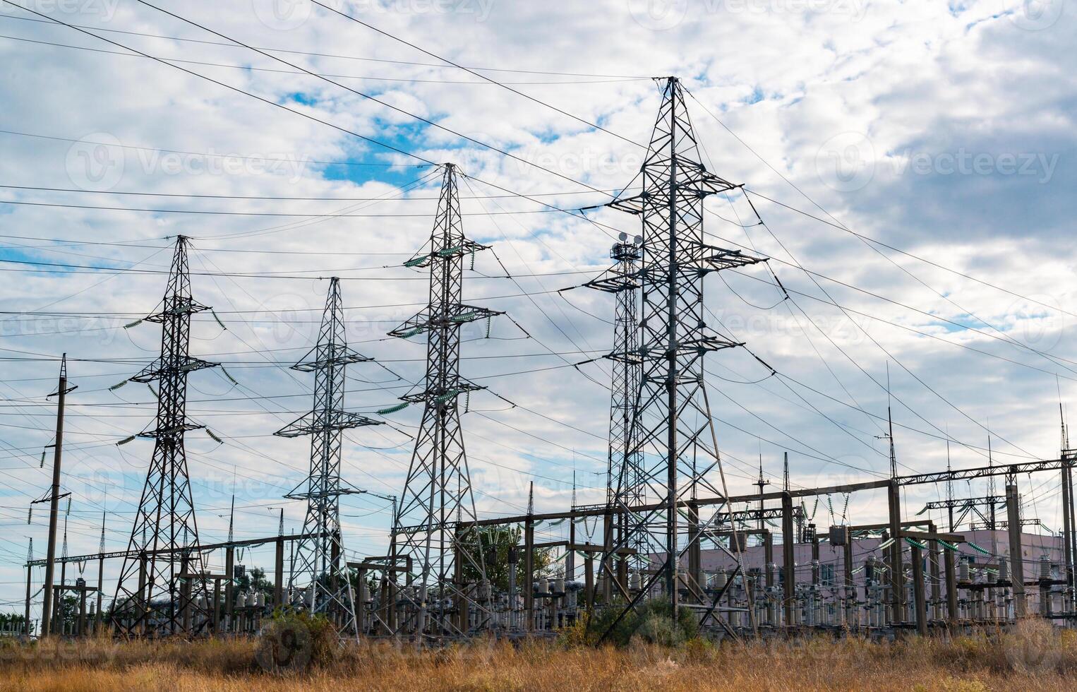 High-voltage lines on steel structures with wires against the background of the sky with clouds photo