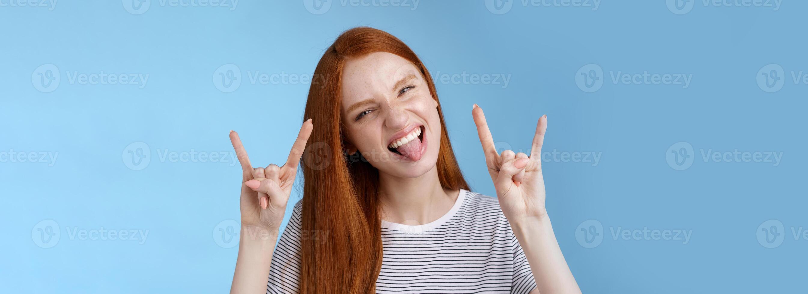 Daring carefree playful excited good-looking funny redhead girl having fun show tongue squinting do thrilled grimace make rock-n-roll heavy metal sign enjoy awesome party cool concert photo