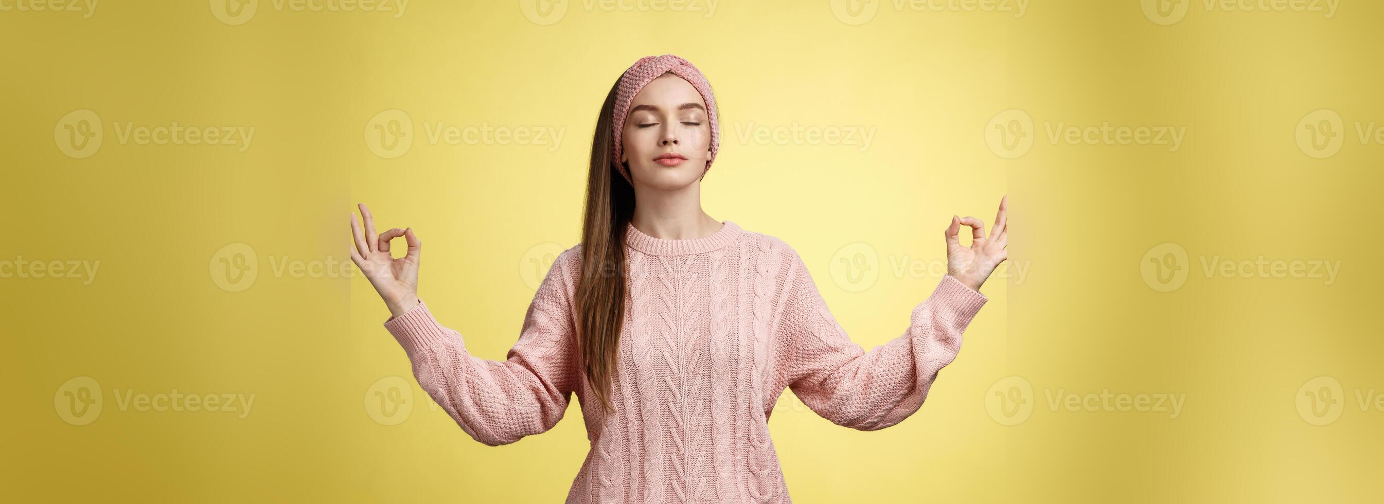 No stress. Pretty young female student not worry, releasing negative emotions during yoga training session standing in lotus pose, breathing smiling relieved happy, showing mudra sign feeling relaxed photo