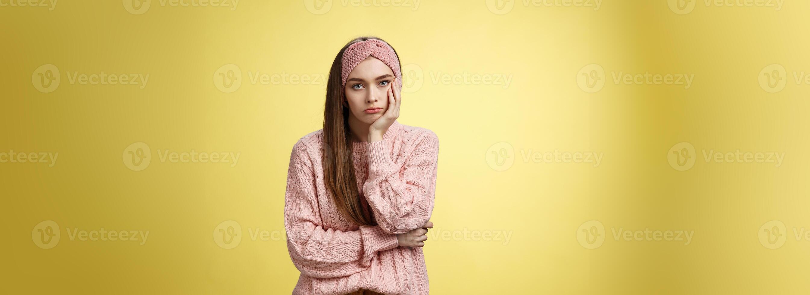 How boring. Indifferent upset gloomy girl missing party feeling bored leaning on palm reluctant, sad looking careless at camera visiting uninteresting lecture, suffering boredom over yellow wall photo