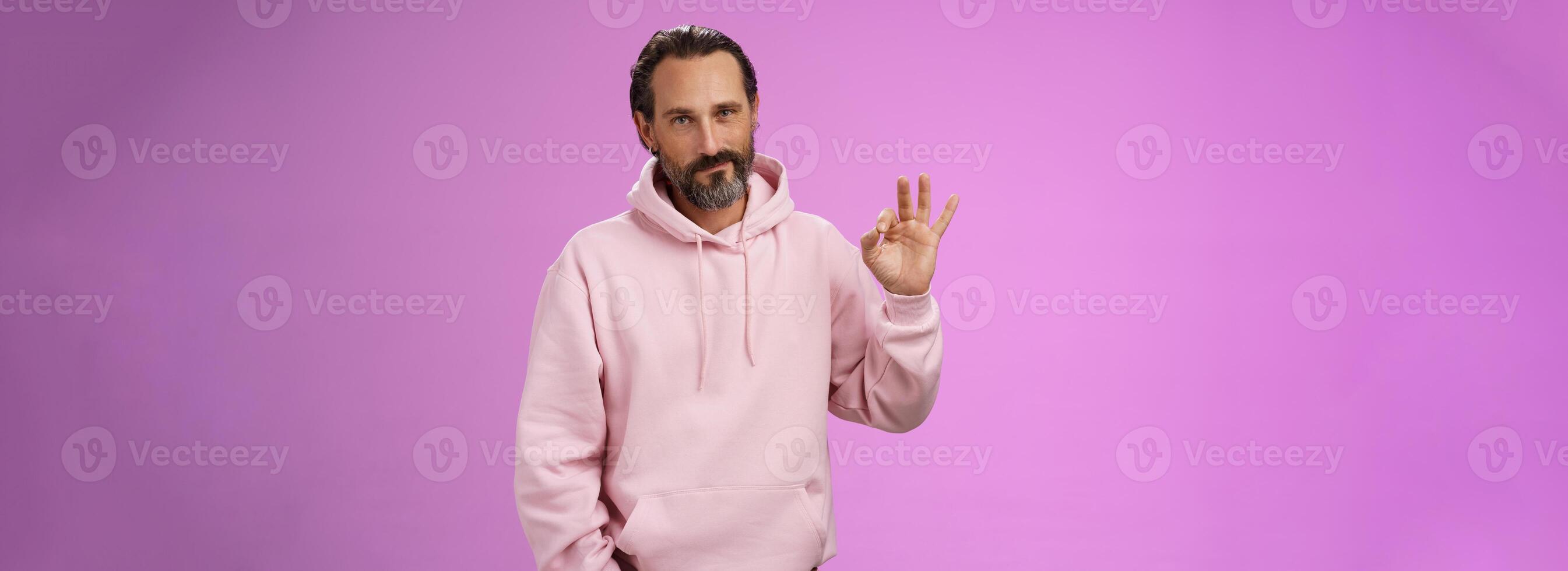 Confident good-looking lucky old macho guy bearded grey hair in stylish pink hoodie hold hand pocket show okay ok approval gesture smirking delighted agree daughter choice, posing supportive photo