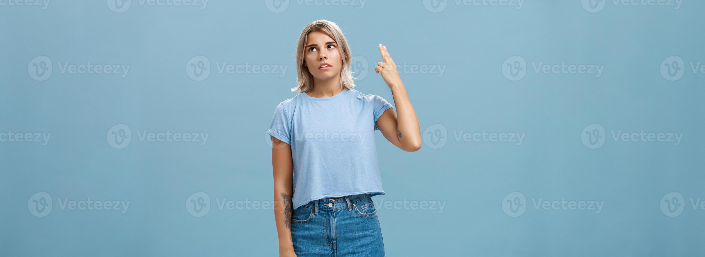 Stop teaching me how live my life. Portrait of irritated displeased attractive blonde female in denim shorts and casual t-shirt rolling eyelids from annoyance showing gun gesture as if blowing brains photo