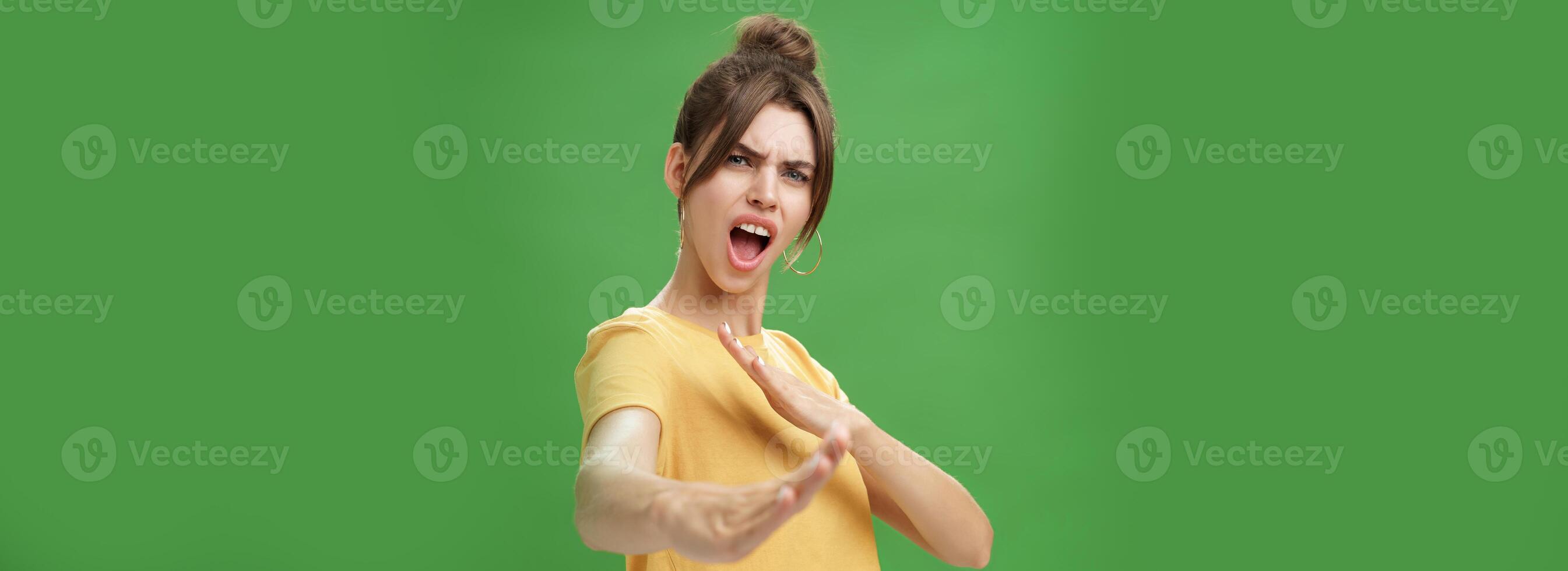 Not mess with this girl. Portrait of funny and emotive charismatic young woman standing in martial arts pose, showing fighting skills yelling kiya, open mouth frowning making karate movements photo