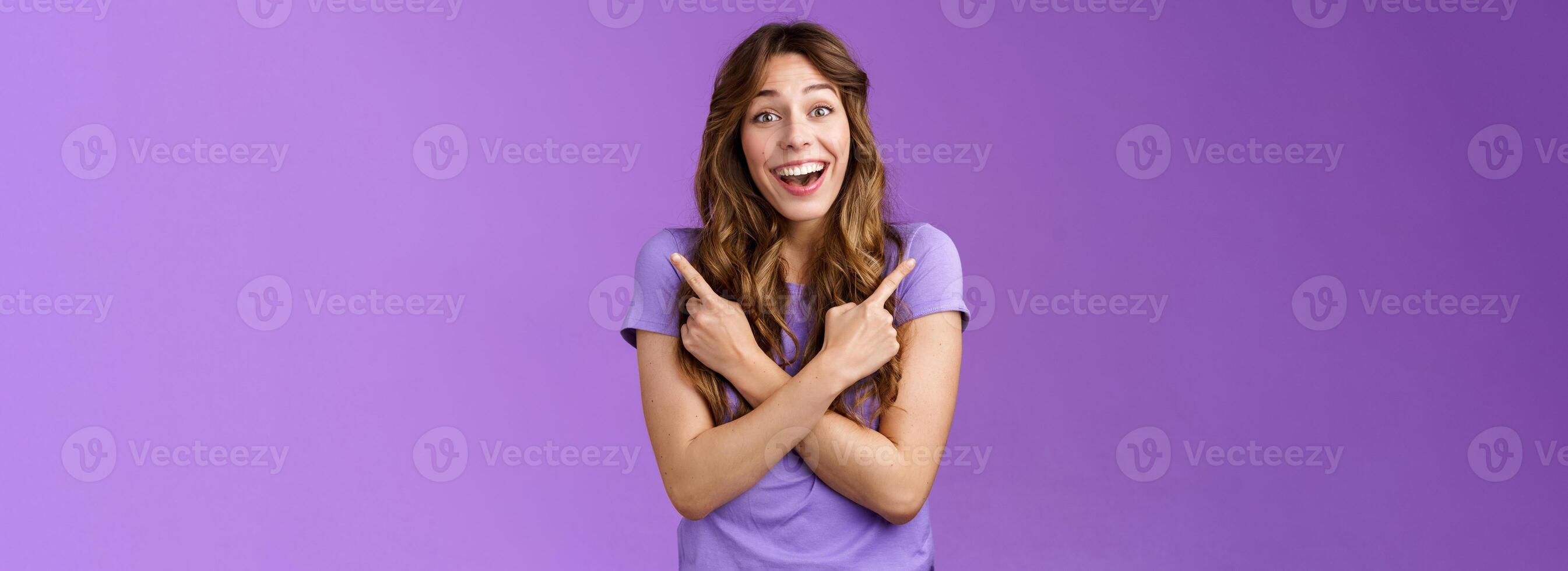 Lively surprised charismatic curly girl fascinated look admiration joy picking between awesome opportunities amazed excellent choices pointing sideways left right make decision purple background photo