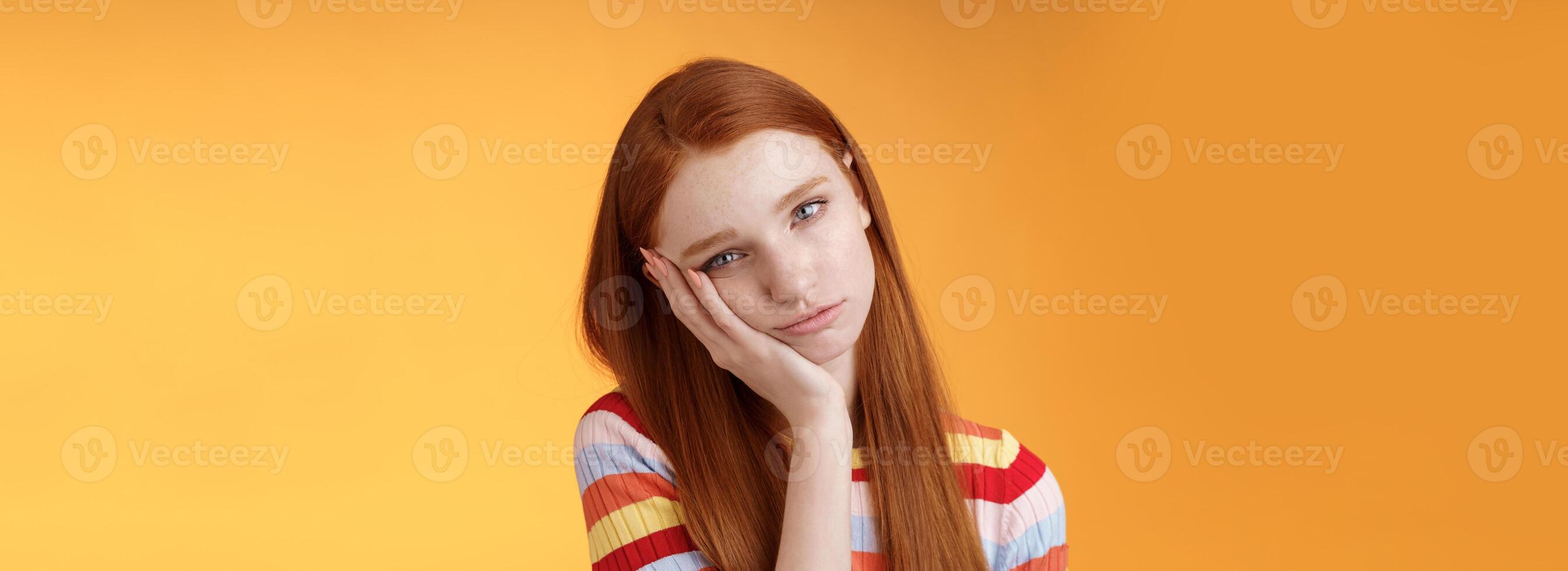 Indifferent careless sleepy redhead silly female student lean palm looking bored uninterested listen lame stories wanna escape standing exhausted lacking interest, posing orange background photo