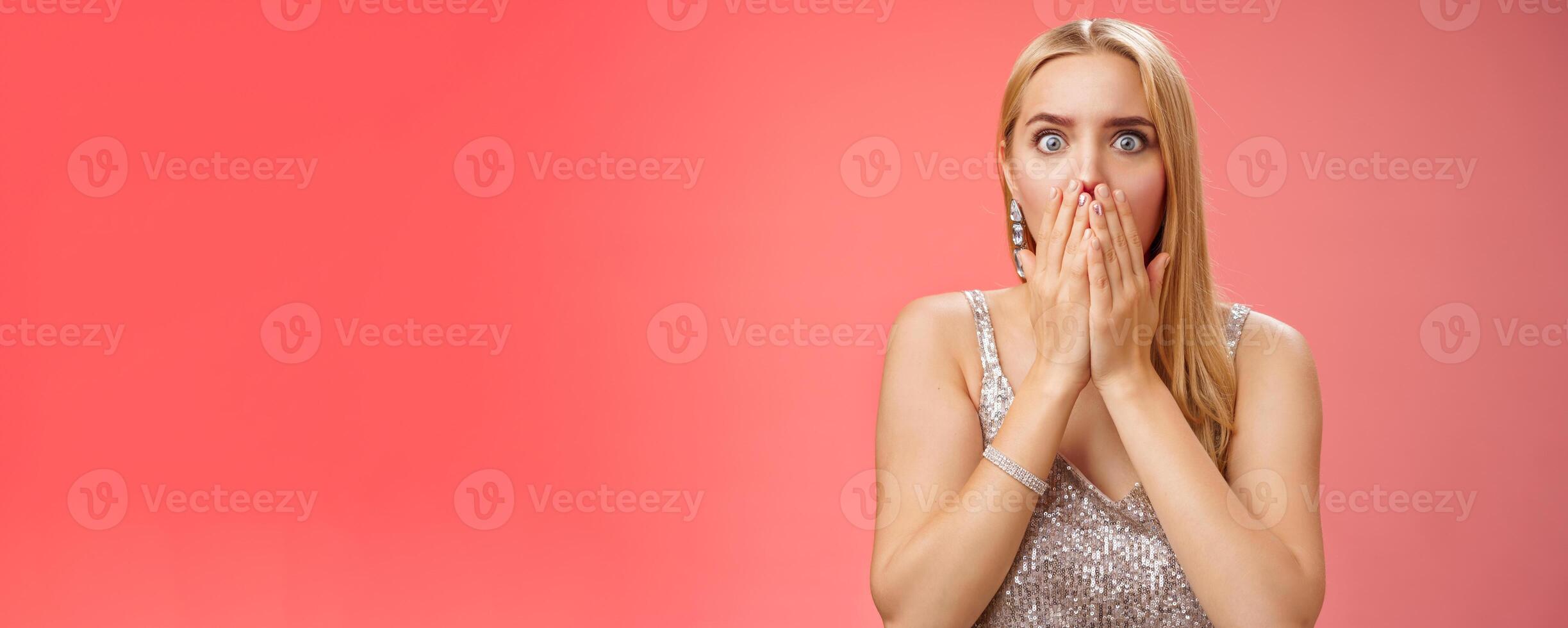 Concerned shocked worried blond woman terrified gasping cover mouth hands pray gesture widen eyes witness terrible accident worry expressing empathy pity, standing red background uneasy photo