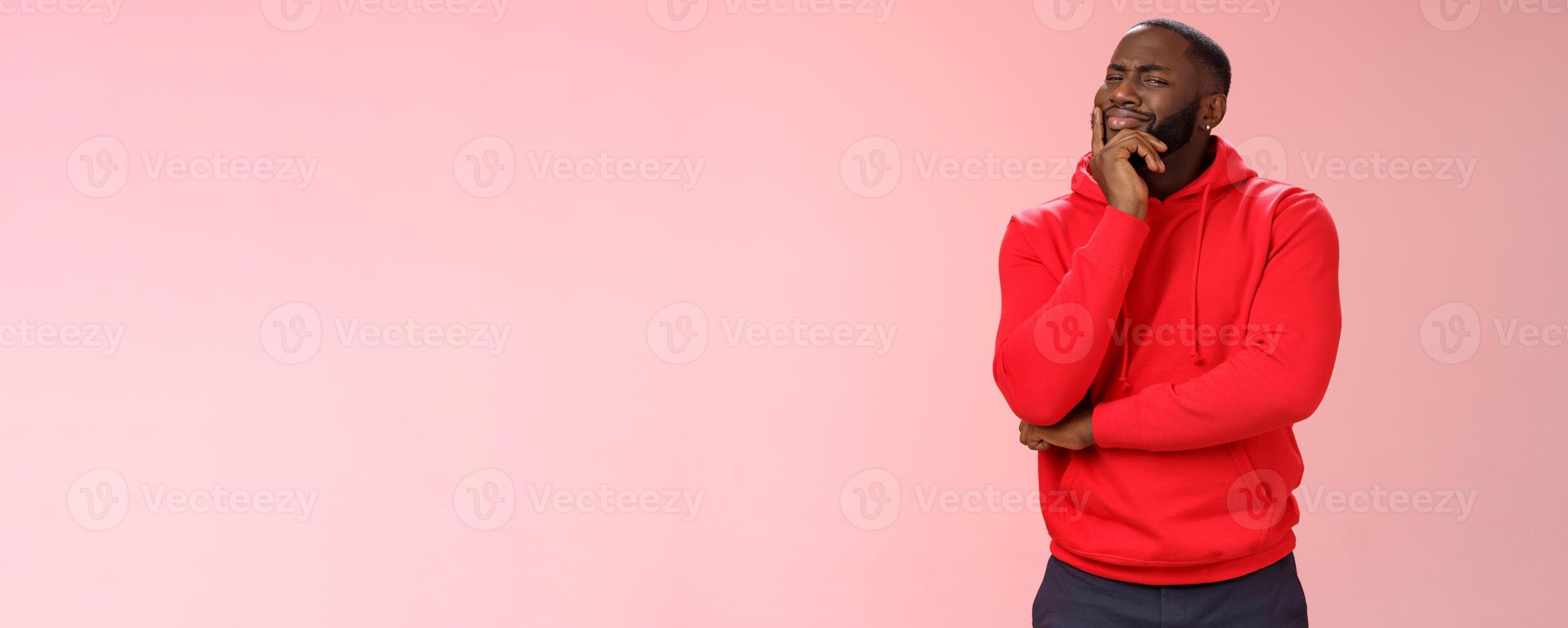 Doubtful sceptical young african-american hesitant bearded guy frowning sarcastic unsure touching chin thoughtful having bad feeling about idea, look disbelief camera, standing pink background photo