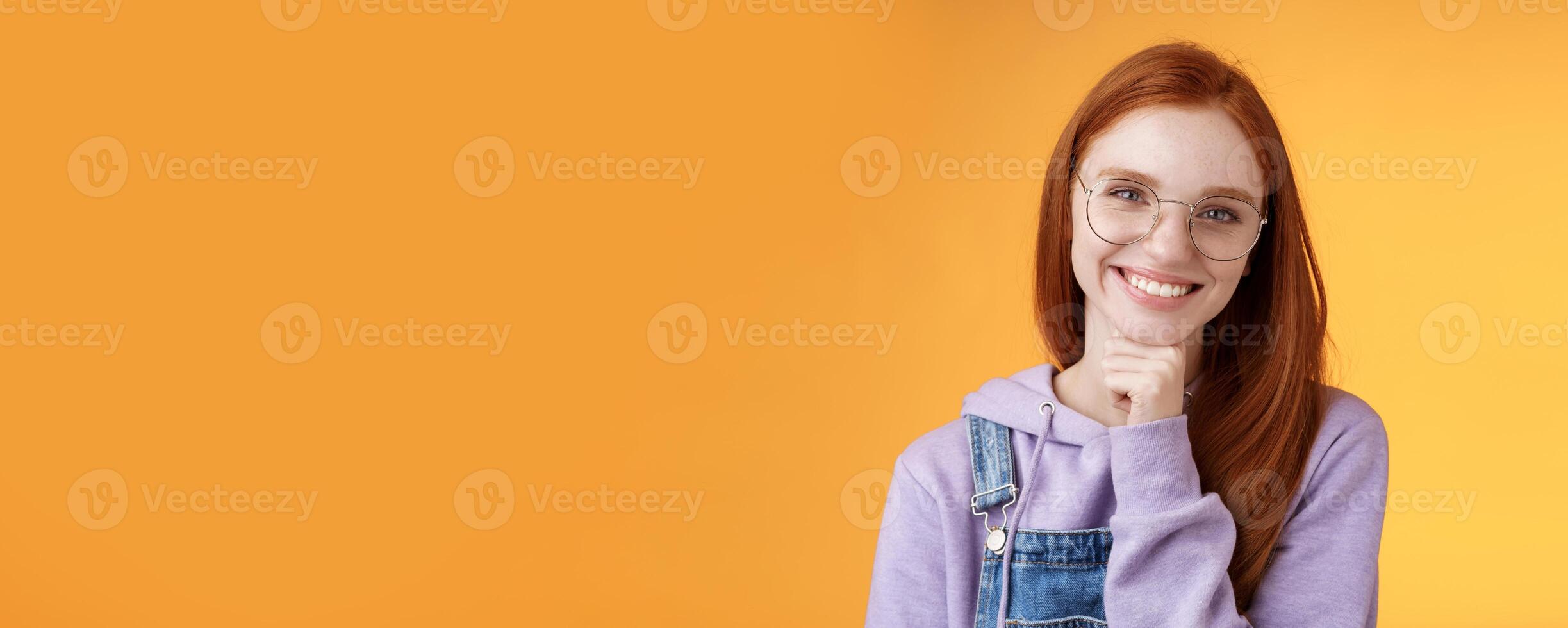 Creative outgoing young charismatic redhead female coworker discuss casual staff smiling laughing happily have pleasant conversation look camera amused tender touch chin, orange background photo