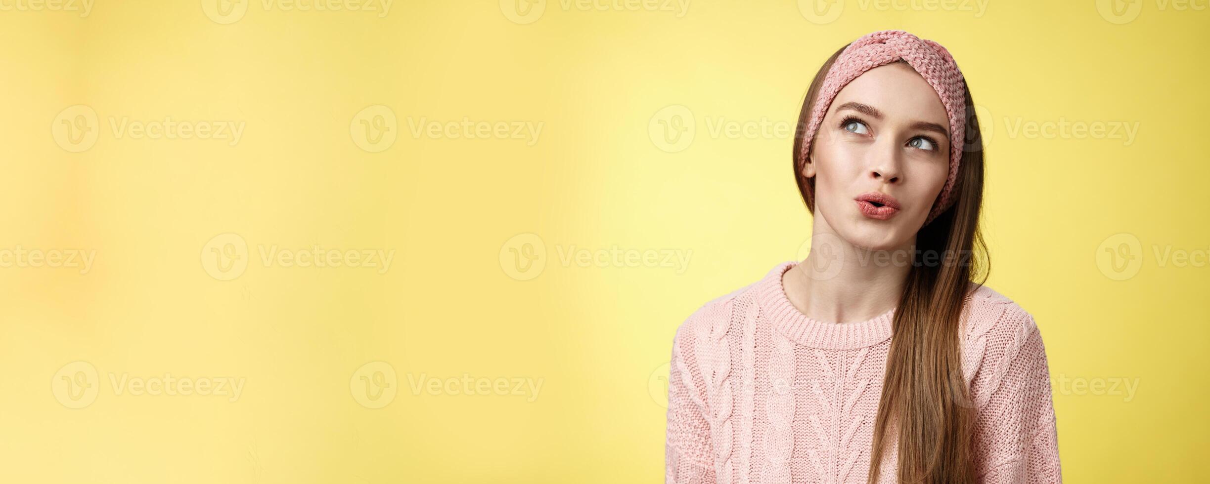 Cute pretty silly girl sharing dreams and fantazies, daydreaming, thinking about desires, speaking about what she wants, daydreaming looking at upper left corner thoughtful, folding lips amused photo