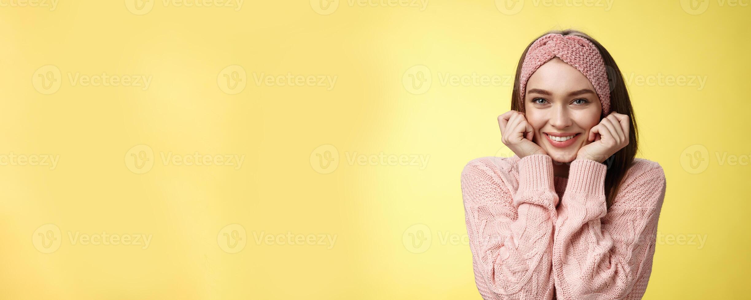 Waist-up shot of silly glamour timid girlfriend in knitted sweater shining from joy and positive emotions, holding hands on cheeks delighted and pleased blushing joyfully, standing amused photo