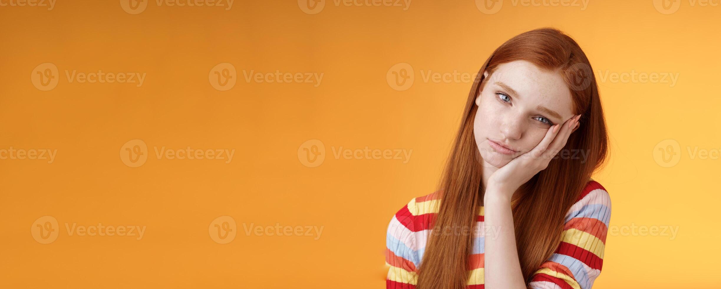 Indifferent careless sleepy redhead silly female student lean palm looking bored uninterested listen lame stories wanna escape standing exhausted lacking interest, posing orange background photo
