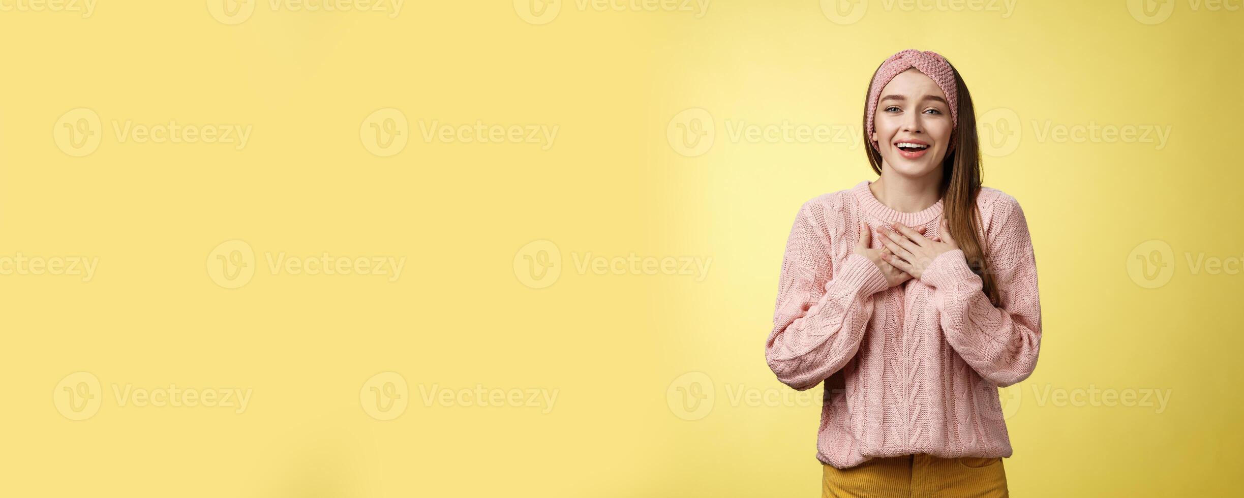 Grateful delighted charming young 20s woman wearing sweater pressing arms to chest happily, thankful, expressing gratitude, heartfelt appreciating gesture smiling amused, in love with romantic gift photo