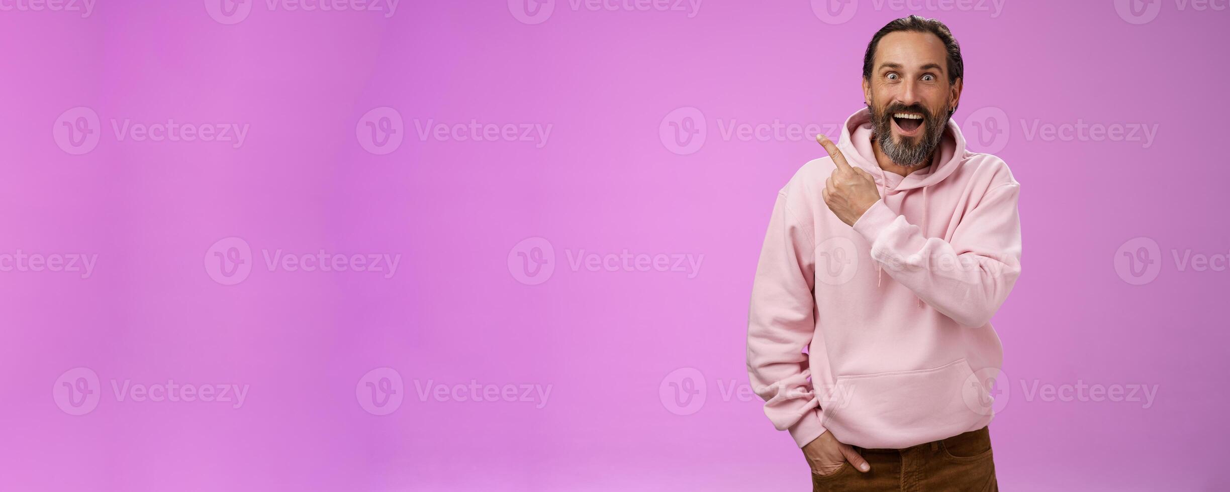 Speechless excited impressed handsome bearded man grey hair widen eyes surprised astonished wow drop jaw gasping thrilled pointing upper left corner see famous star, purple background photo