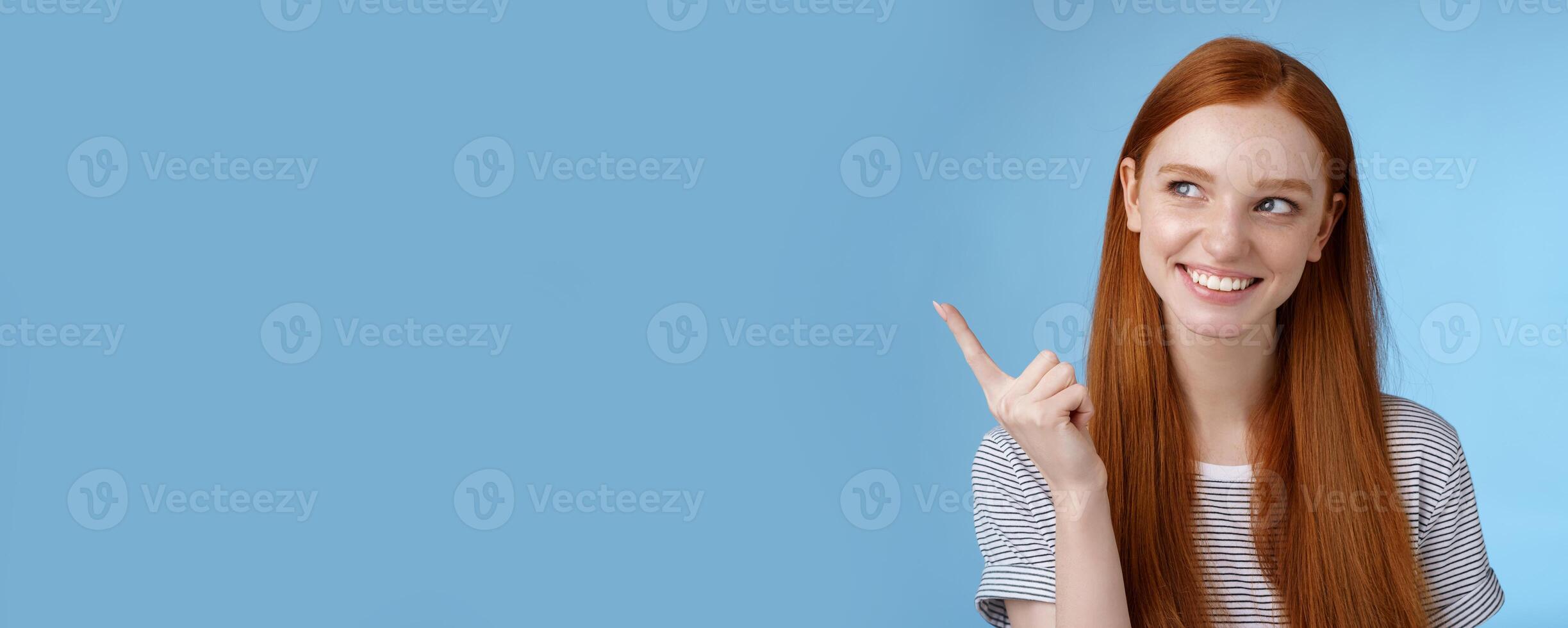 Wow interesting. Curious attractive smiling young 20s female student find good offer price product look pointing upper left corner intrigued grinning satisfied have perfect idea how use copy space photo