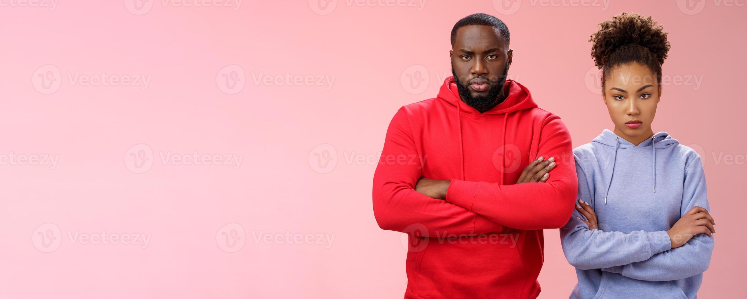 Two attractive african friends coworkers serious-looking standing confident strong pose arms crossed chest look determined focused camera wanna beat rival team computer game, self-assured photo