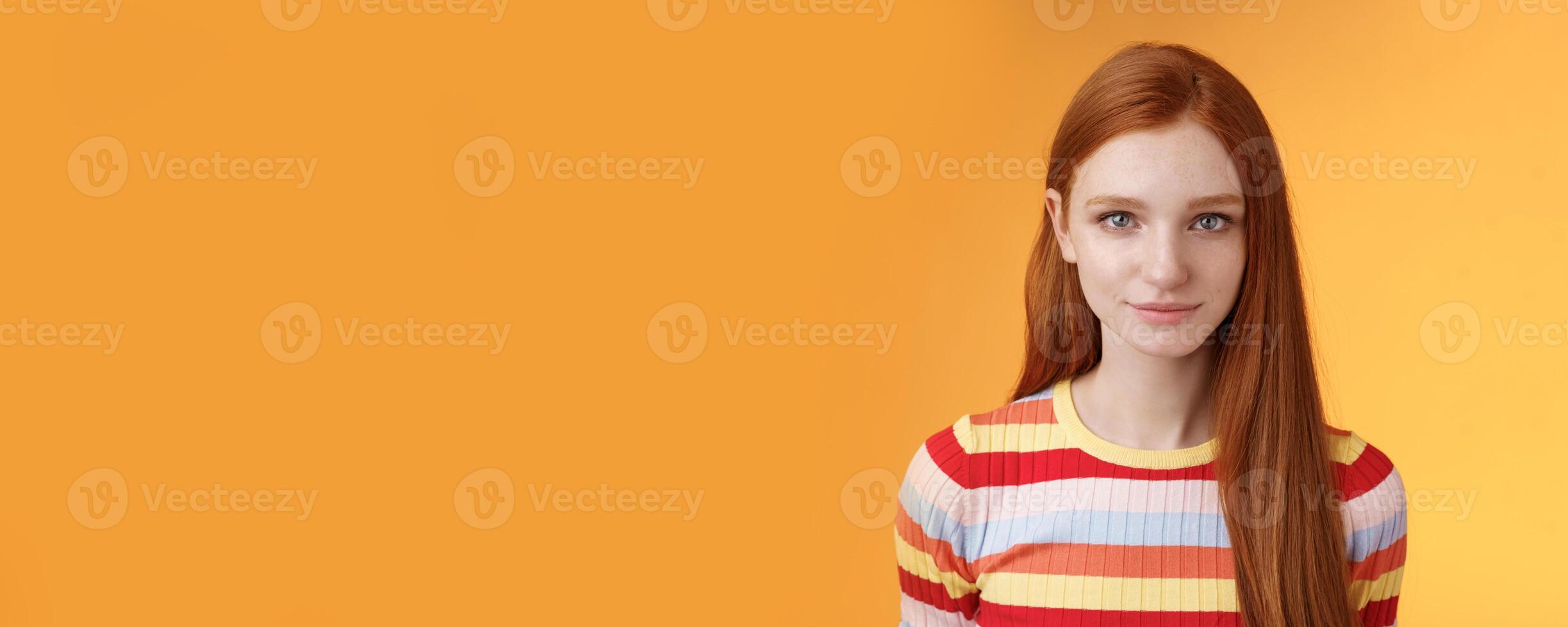 Attractive young sincere redhead girl clean pure perfect skintone smiling modest look camera friendly delighted standing relaxed awaiting gazing silly tenderly, posing orange background photo