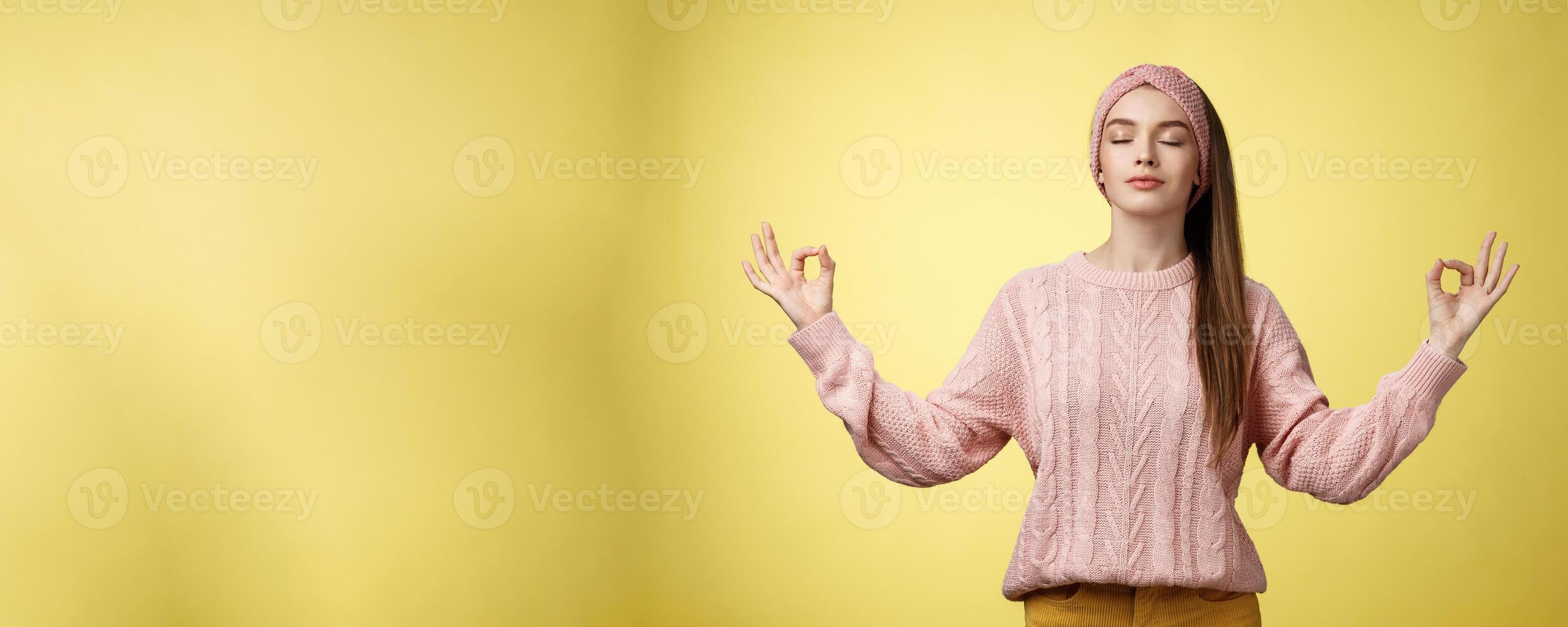 No stress. Pretty young female student not worry, releasing negative emotions during yoga training session standing in lotus pose, breathing smiling relieved happy, showing mudra sign feeling relaxed photo
