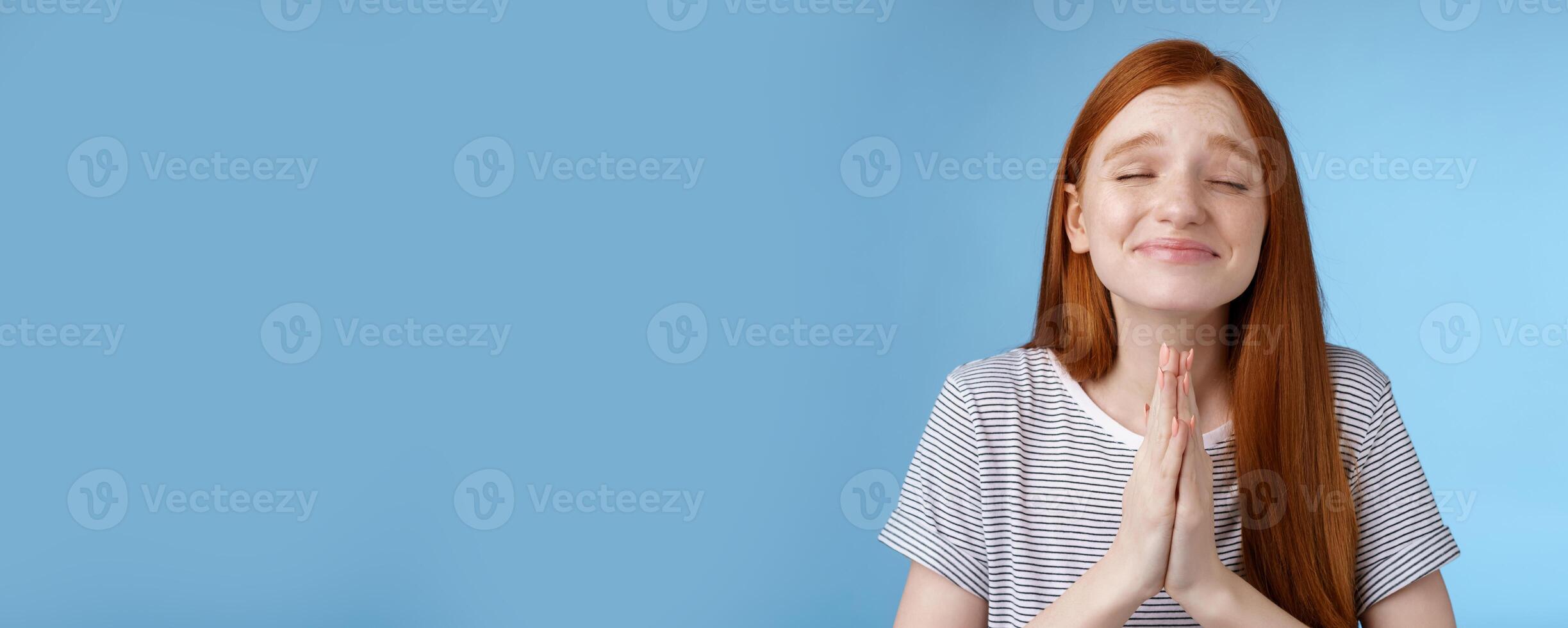 Girl making wish bottom heart willing dream come true press palms together pray supplicating close eyes smiling sincere belief desire fulfill anticipating miracle, standing blue background photo