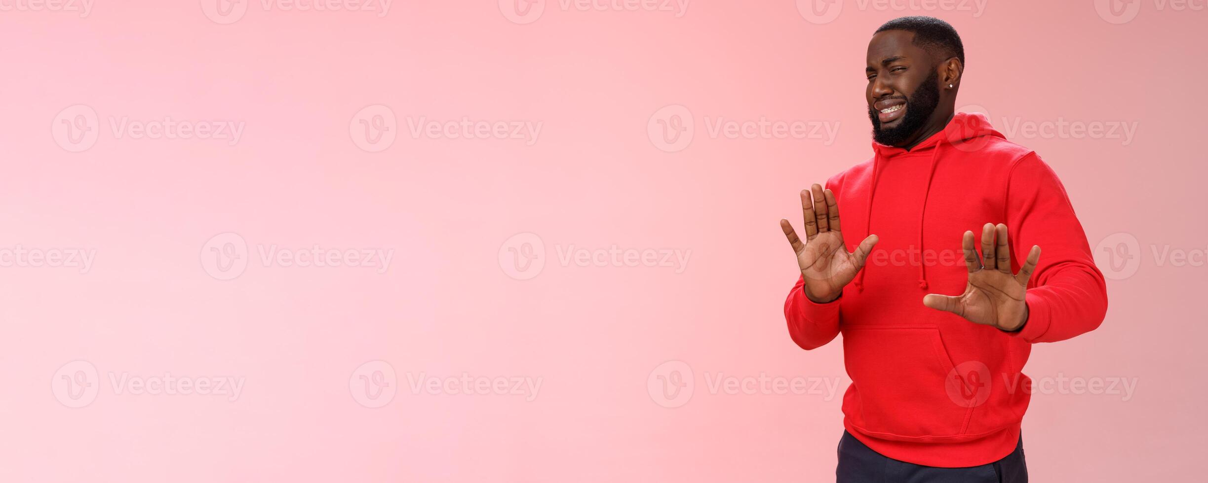 Awkward african american guy step back cringing dislike unwilling go party raise hands no thank stop refusal gesture smiling perplexed trying escape duties, standing bothered rejecting offer photo