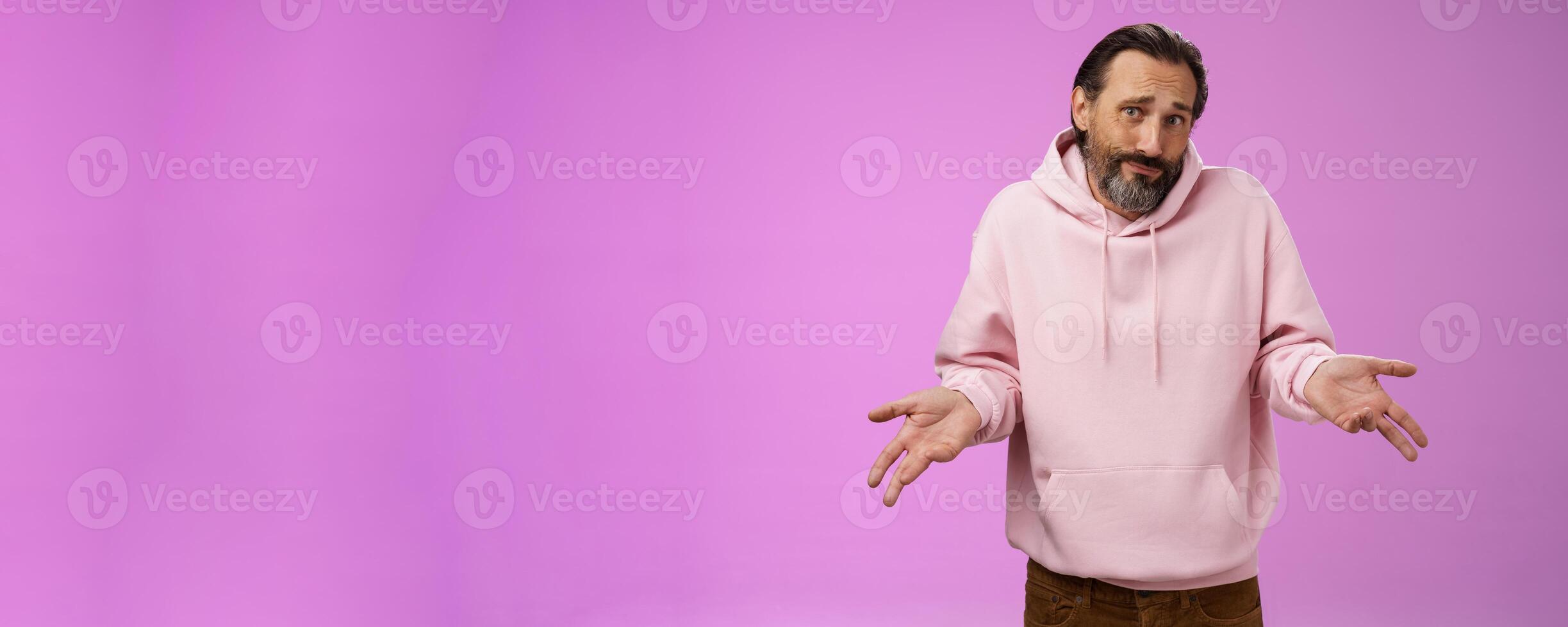 Portrait clueless unaware father cringing smirking uncertain shrugging hands spread sideways no idea, look questioned doubtful cannot answer unknown topic, standing purple background photo