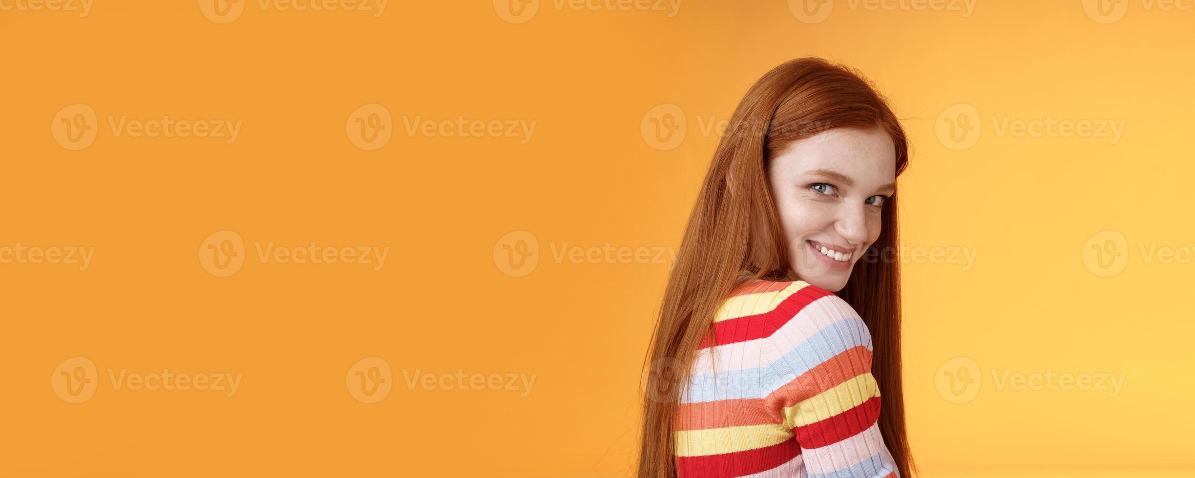Tenderness, romance, seduction concept. Attractive cheeky flirty young redhead daring girl turn behind look shoulder camera smiling silly coquettish giggle express sympathy affection photo