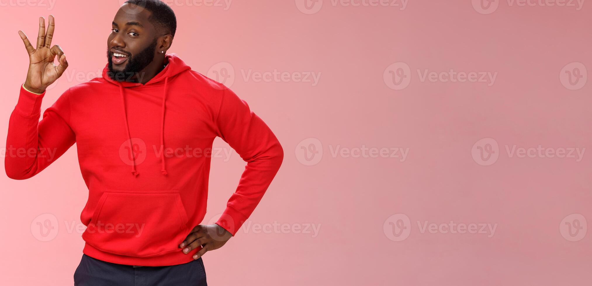 Guy hold everything under control assuring customer show okay sign. Portrait charismatic cheeky black bearded man say ok smiling assured confident you look perfect, standing pleased pink background photo
