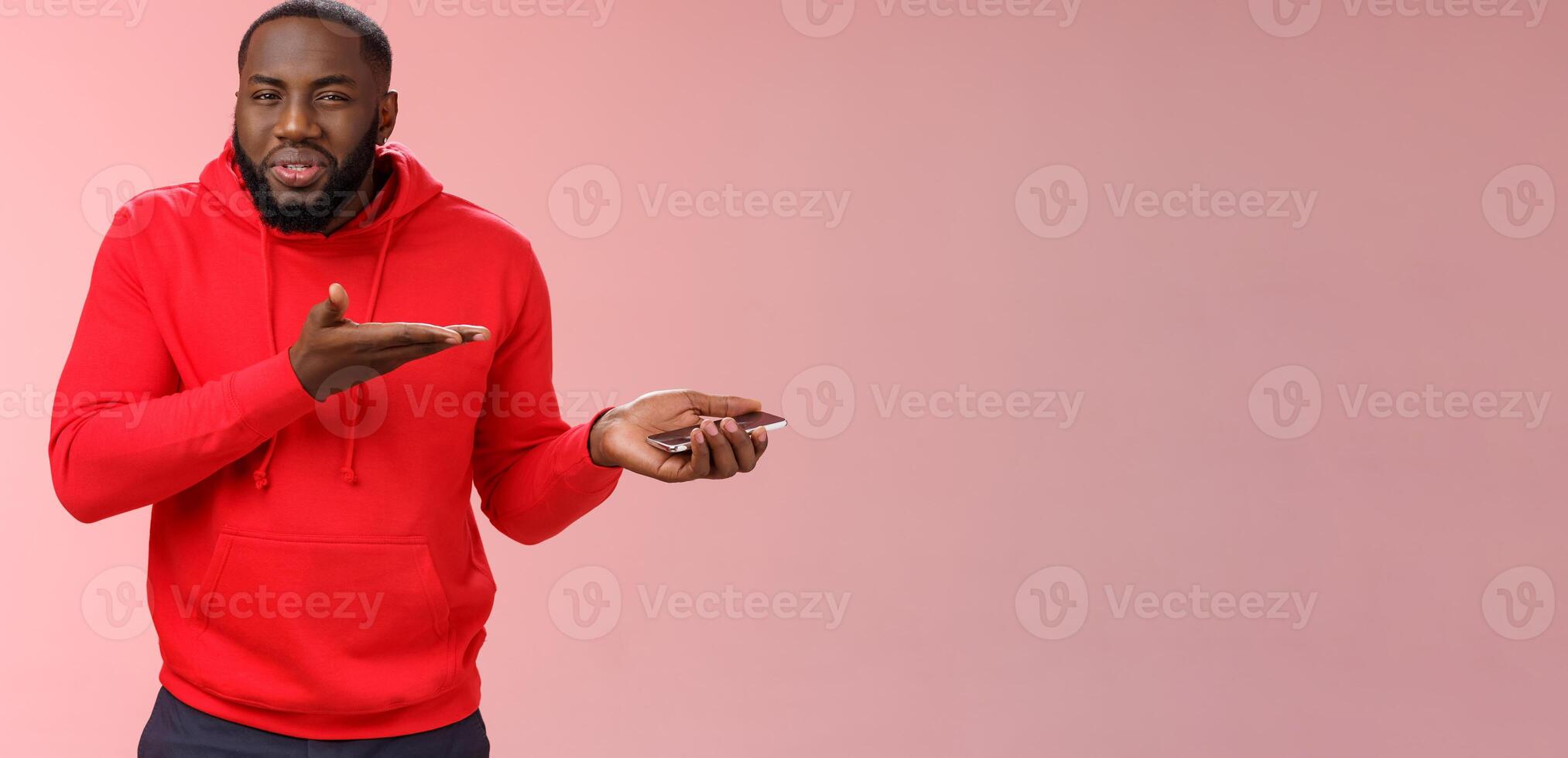 Guy complaining strange text received from girlfriend asking friends advice holding smartphone pointing palm device look frustrated questioned, man confused ridiculous message, pink background photo