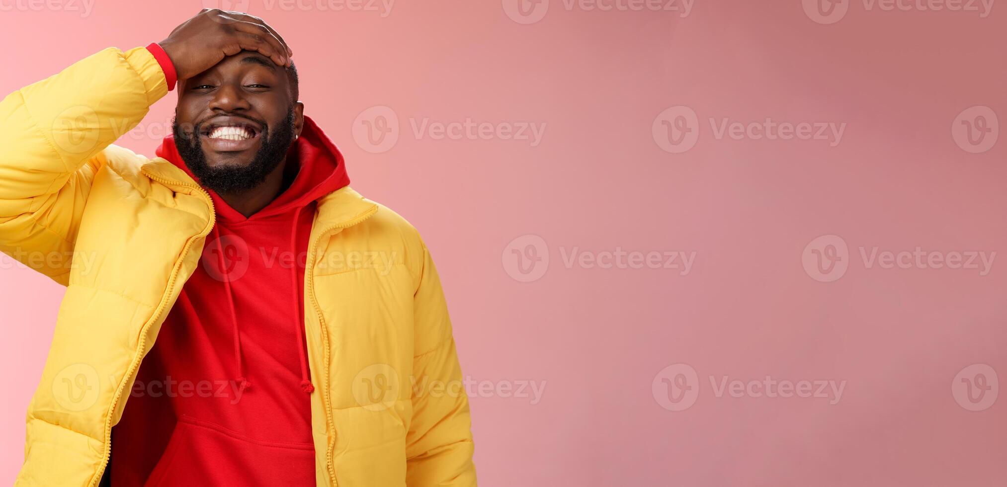 Charming cute black bearded 25s guy forget something stupid silly smiling friendly punch forehead grinning feel awkward say sorry standing pink background joyfully relaxed photo