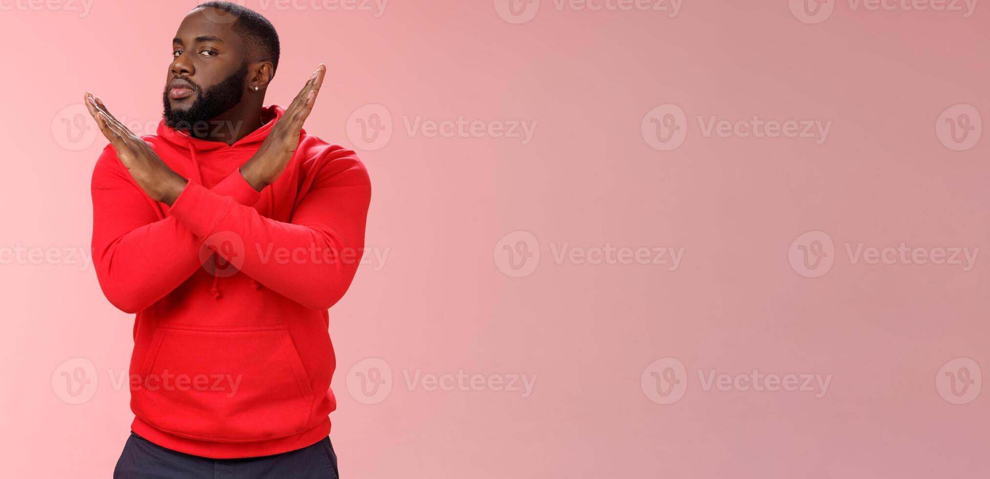 Cut it out. Portrait serious-looking african american male assisant show cross gesture say finish refusing, rejecting offer never gonna do it, standing reluctant pink background negative answer photo