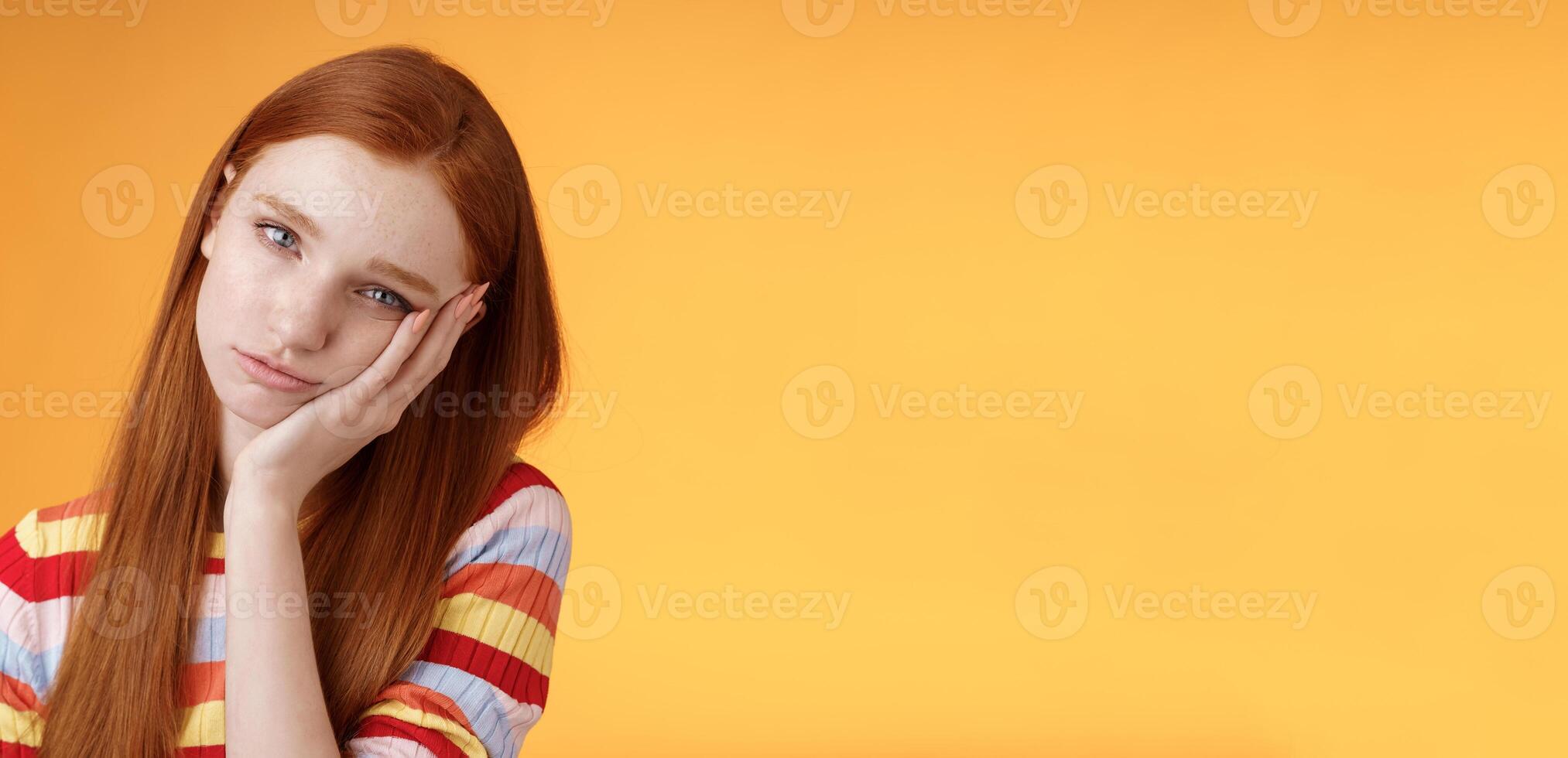 Indifferent careless sleepy redhead silly female student lean palm looking bored uninterested listen lame stories wanna escape standing exhausted lacking interest, posing orange background photo