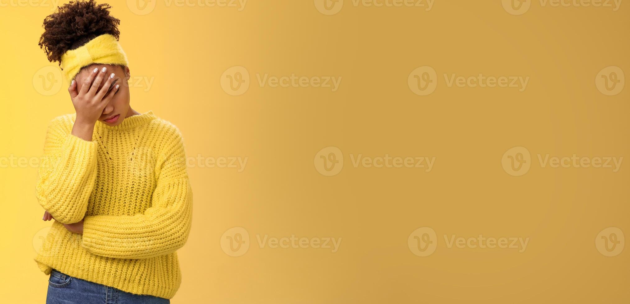 Upset tired african-american female entrepreneur facepalm bow head close eyes palm pressed face embarrassed stupid inappropriate behaviour drunk coworker standing annoyed irritated yellow background photo
