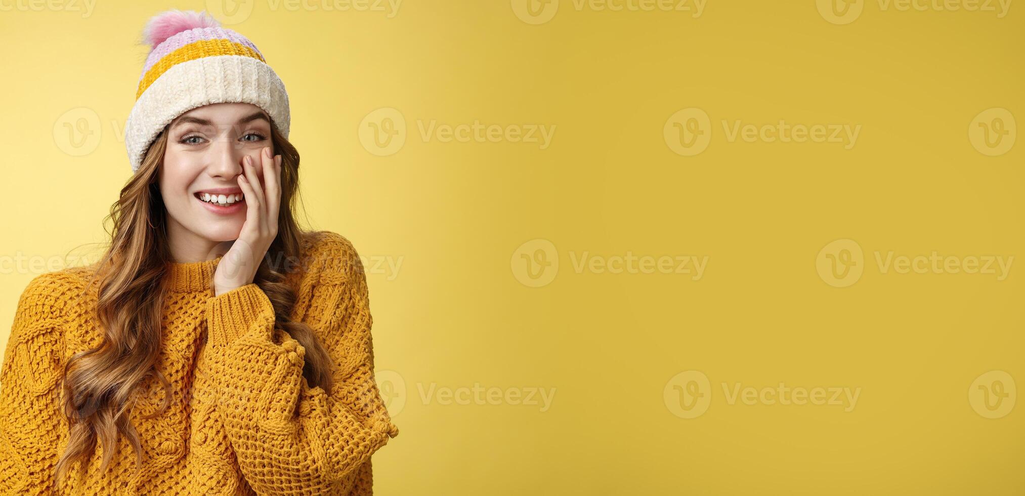 Smiling attractive carefree young 20s woman having fun talking casually nice conversation girlfriend press palm cheek amused blushing receive flirty compliment, standing positive yellow background photo