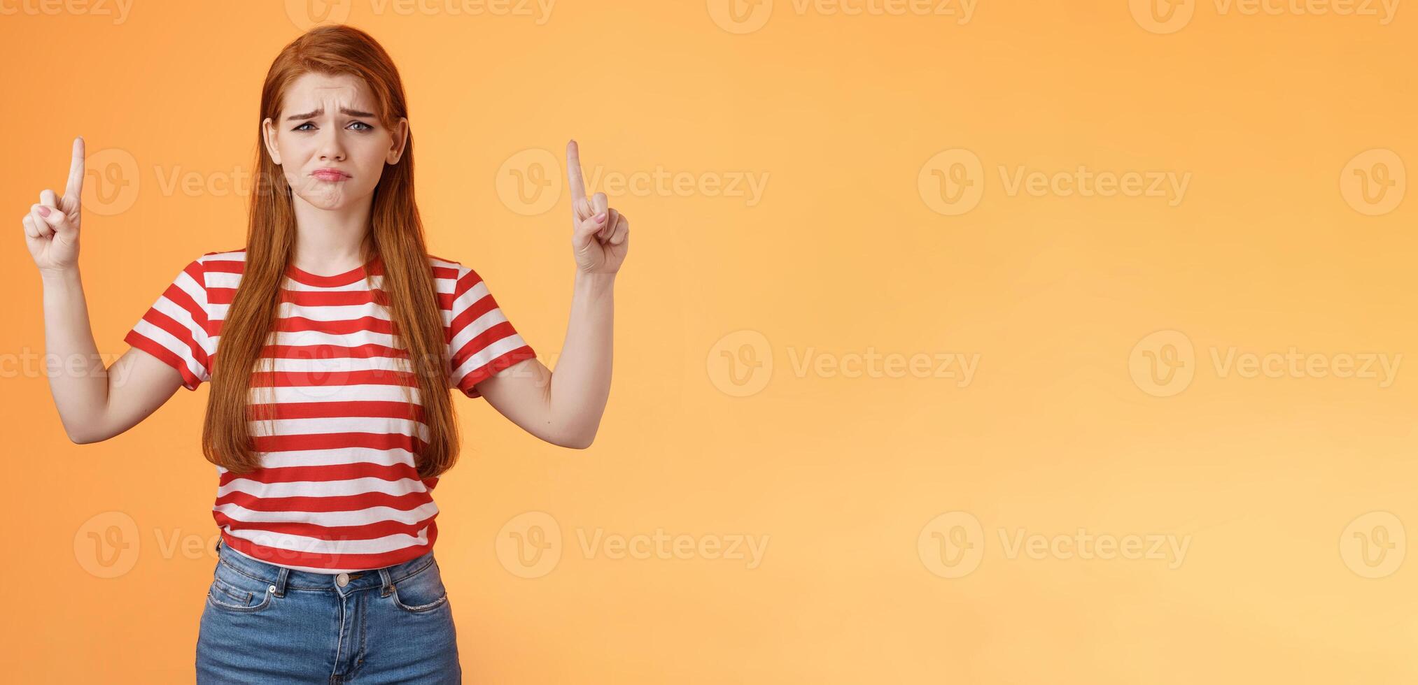 Disappointed upset cute whining timid redhead girl, gloomy face, pulling sad expression, complain, crying feeling regret loss, losing lottery, pointing up displeased, show despair and sorrow emotion photo