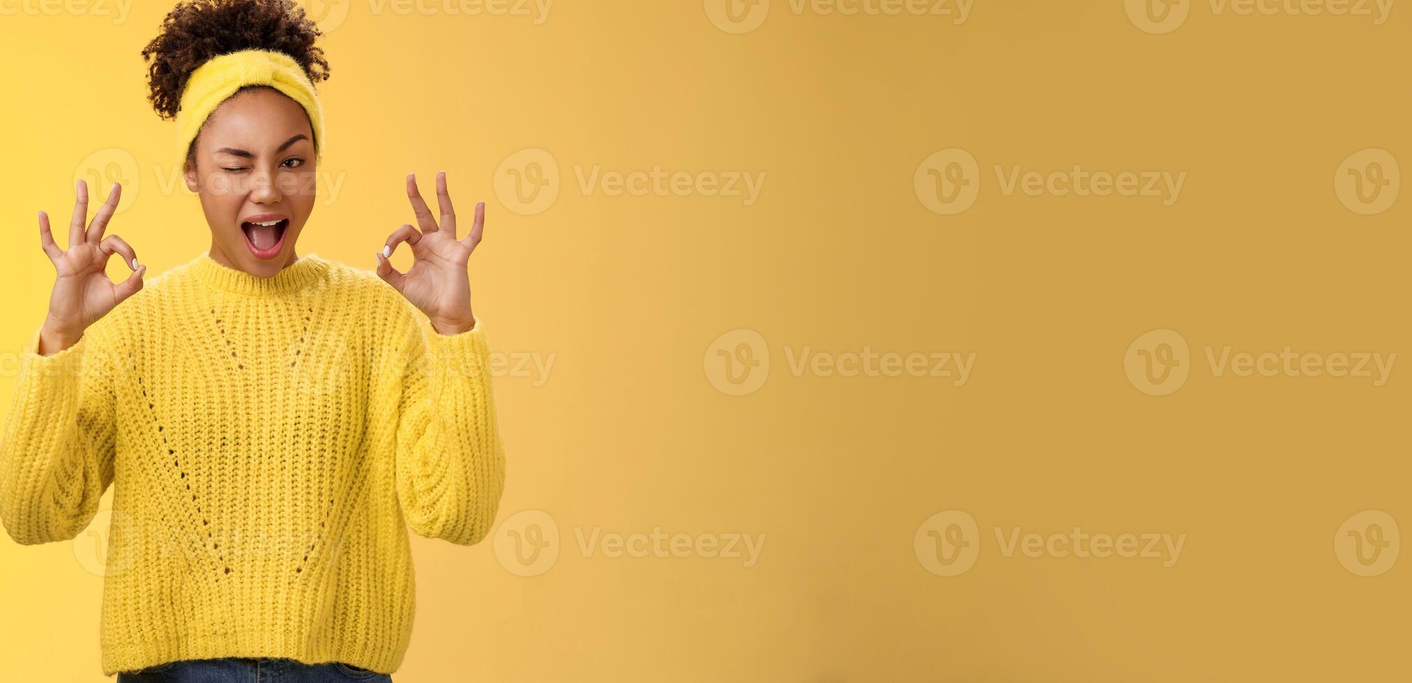Okay I got it. Cute reliable truthful african-american girlfriend assuring friend secret safe winking devious hinting work done okay show ok fine perfect gesture no worry about, yellow background photo