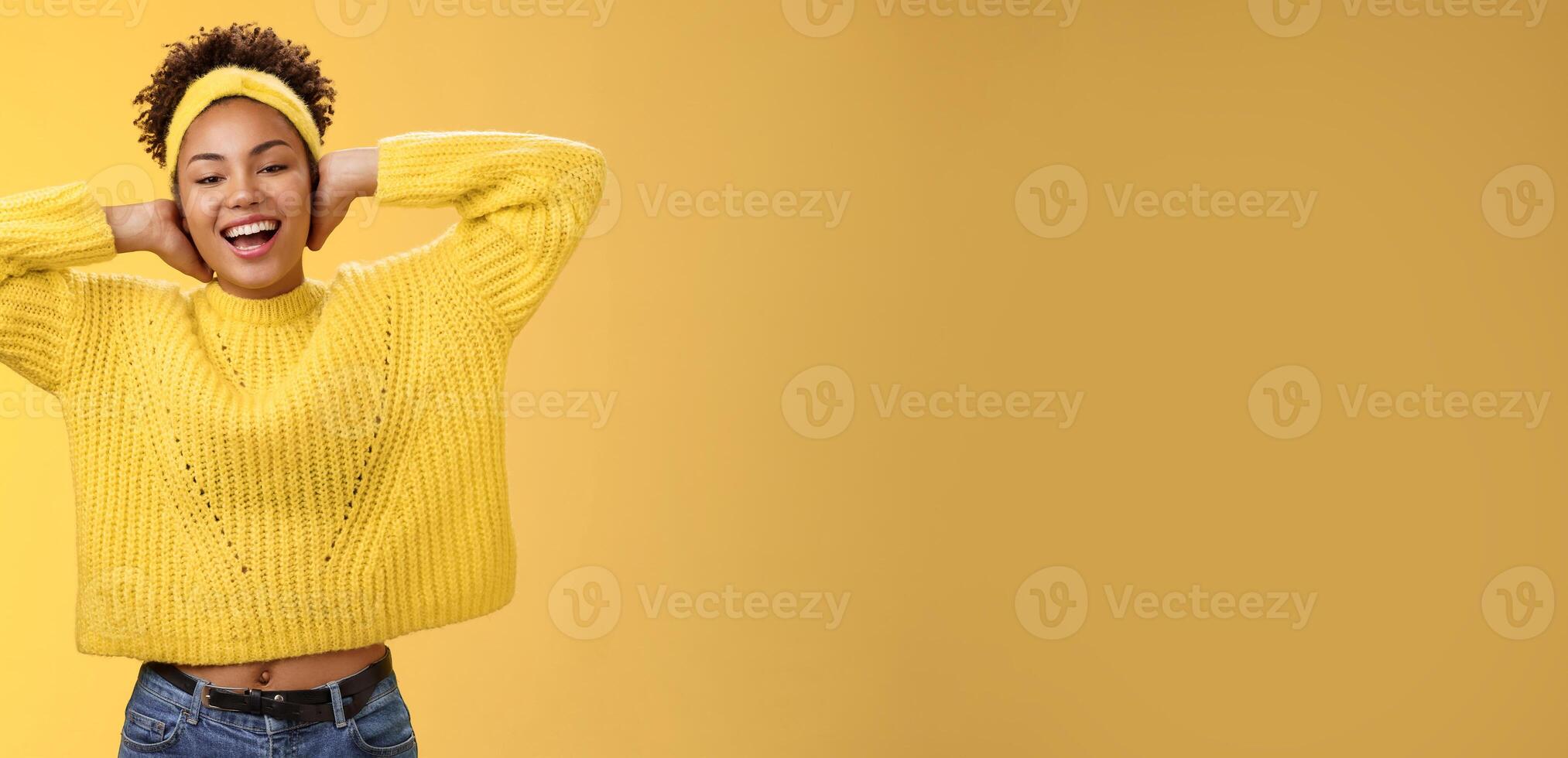 Carefree outgoing young charming african-american girl lay back hands behind head relaxing stretching feel lazy enjoying free day-off smiling broadly spend leisure having fun yellow background photo
