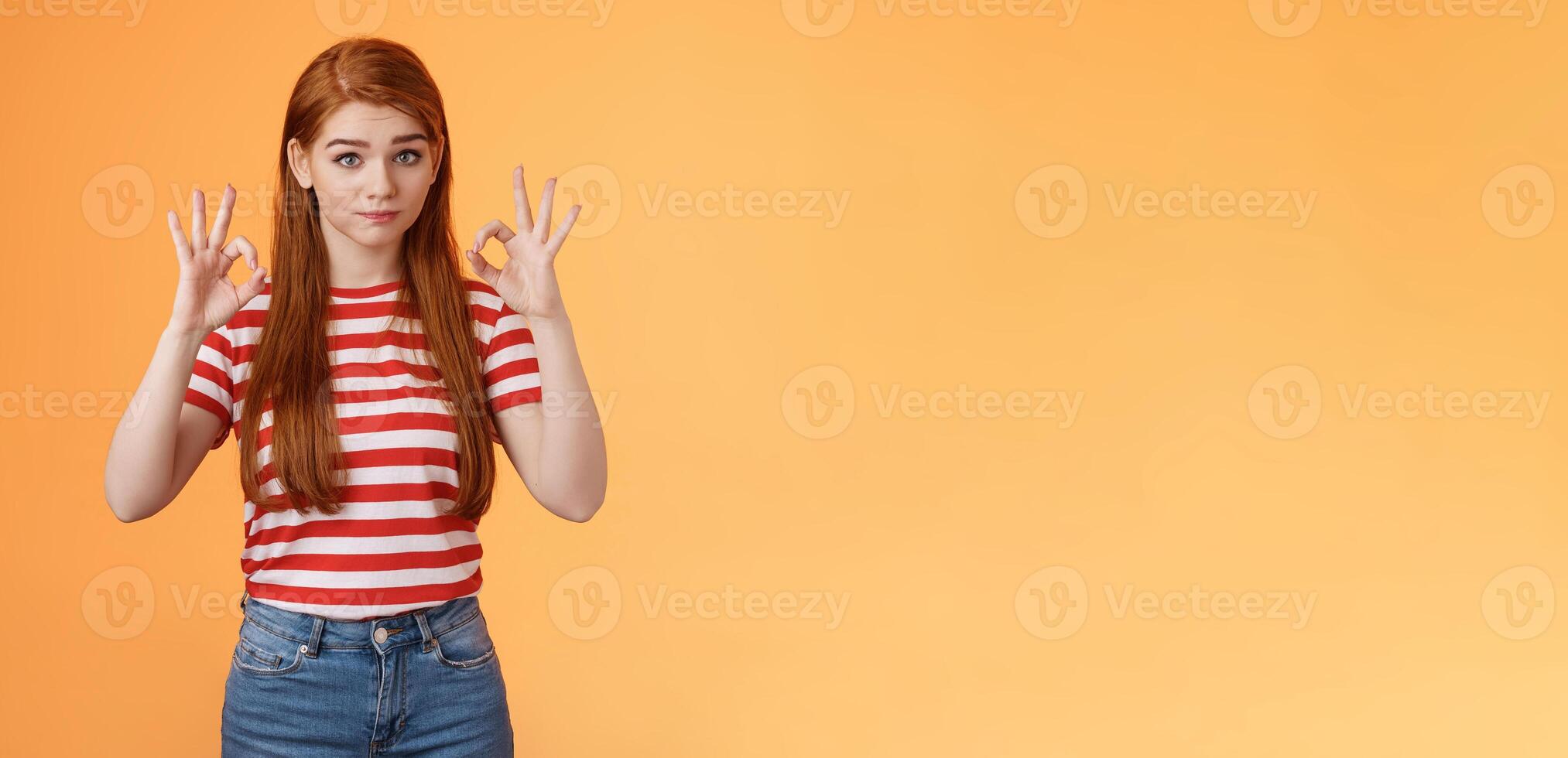 Not bad, but okay. Silly tired redhead woman show approval ok sign, pouting raise eyebrows, feel exhausted after finishing job, show excellent, good work gesture, stand orange background photo