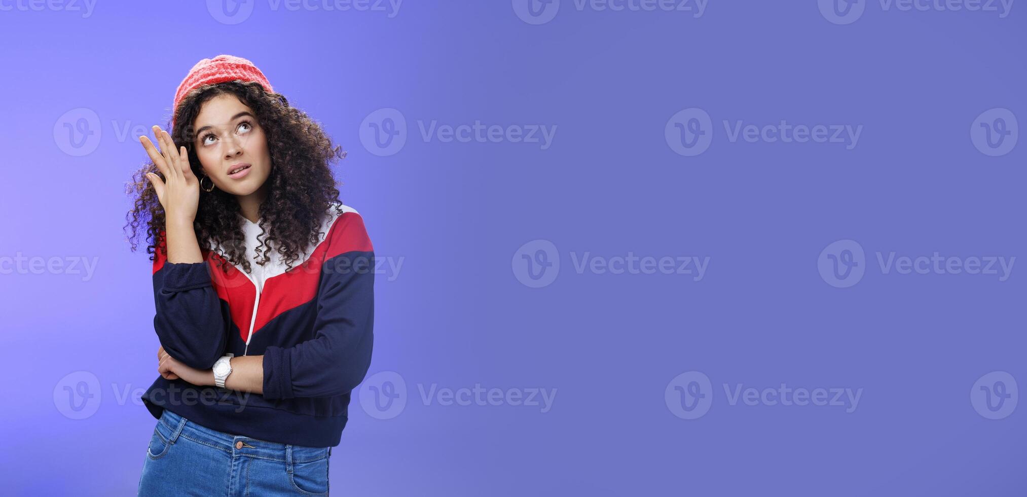 Waist-up shot of bored and annoyed assertive arrogant cool girl in streetstyle outfit rolling eyes up making facepalm and grimacing from irritation and disappointment, posing against blue background photo