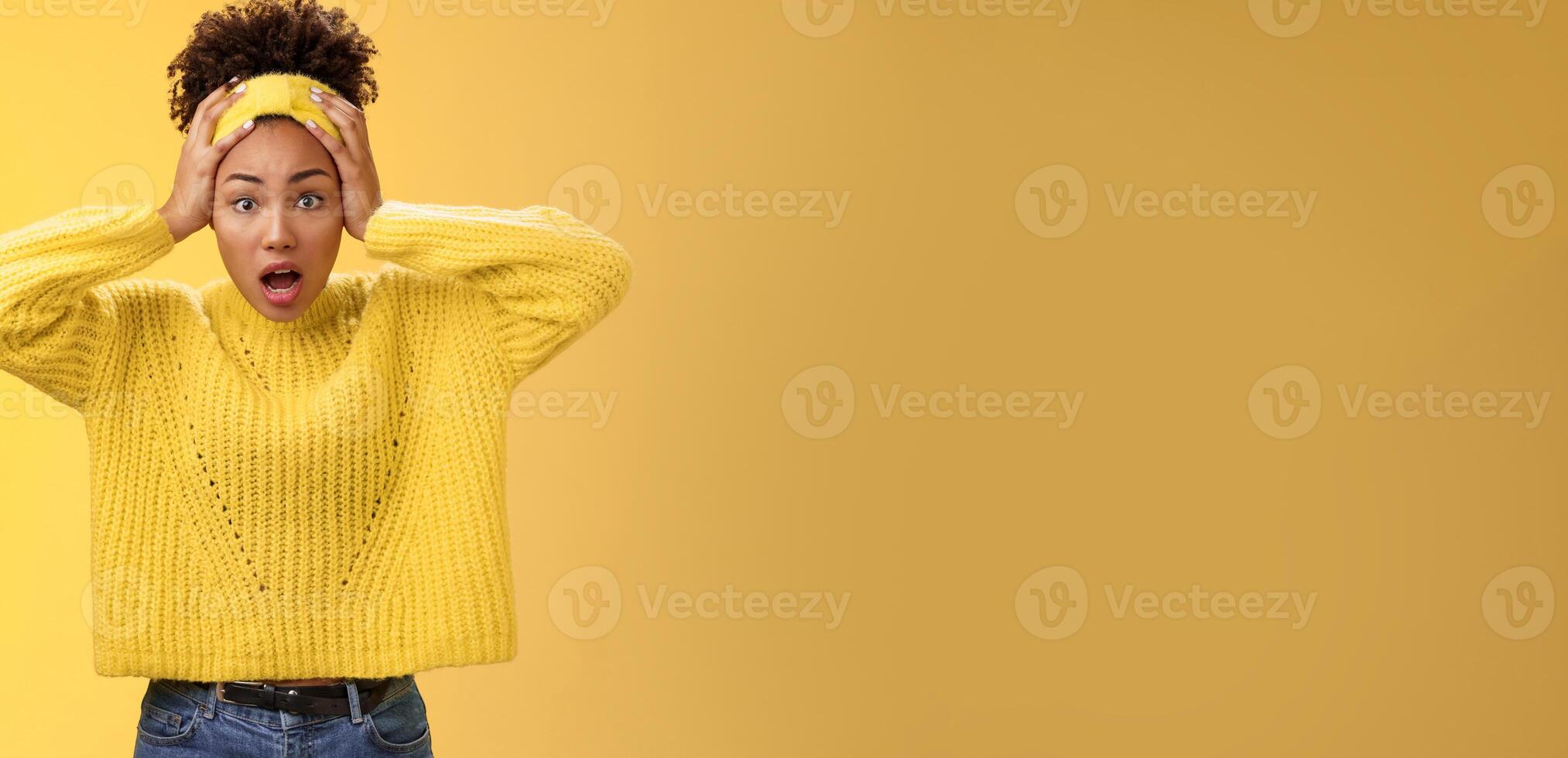Concerned troubled surprised african-american woman gasping shocked hold head widen eyes perplexed face troublesome situation panic unaware what do, standing frustrated yellow background photo