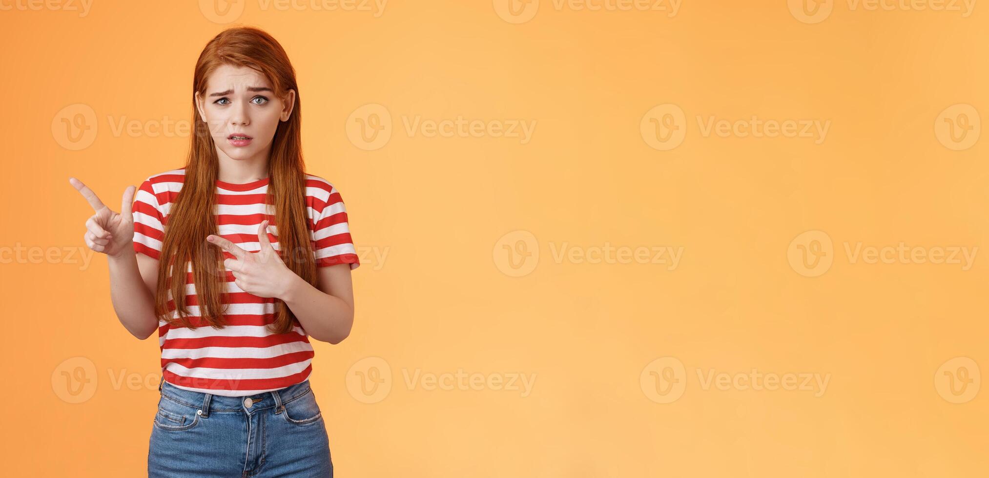Insecure questioned frustrated cute redhead girl feel nervous unsure about suspicious offer frowning, grimacing doubtful and hesitant, pointing left look camera puzzled, asking question photo
