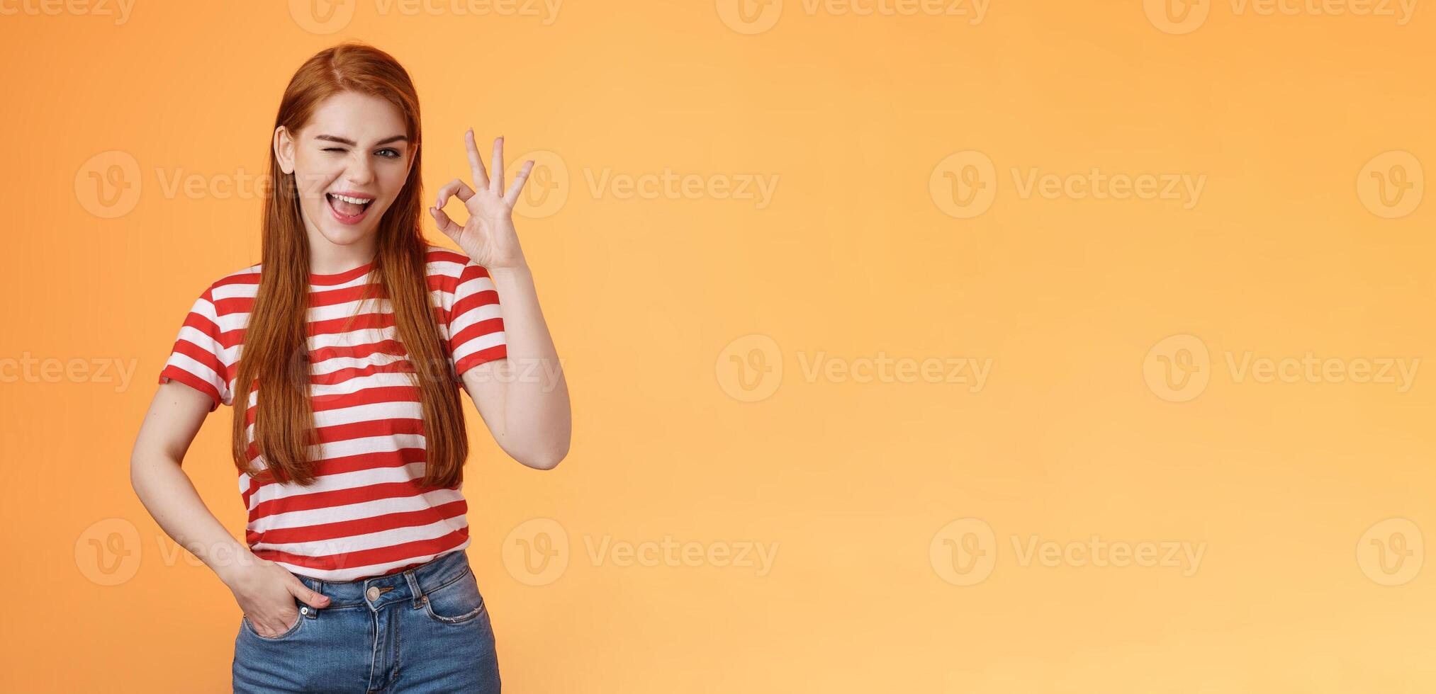 Sassy stylish sly redhead cheerful girl assuring everything excellent, show okay sign and wink cheeky, accept awesome idea, approve good job, express satifaction from positive result, like choice photo