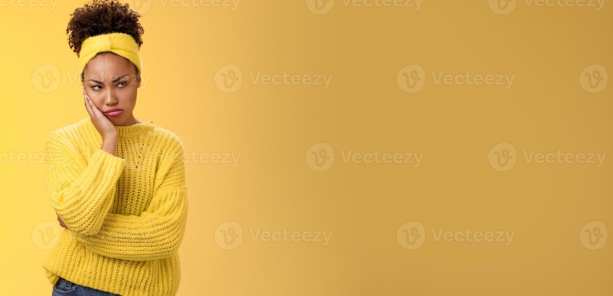 Offended gloomy grumpy pouting young african-american girlfriend feel irritated jealous frowning bothered sulking look away insulted unwilling talk somebody lean hand head standing yellow background photo