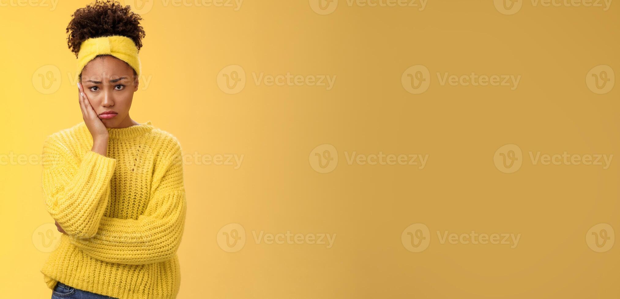 Upset cute gloomy young timid girl offended feel sadness regret touch cheek painful toothache make upset miserable pitty expression, troubled uncertain what do standing insecure yellow background photo
