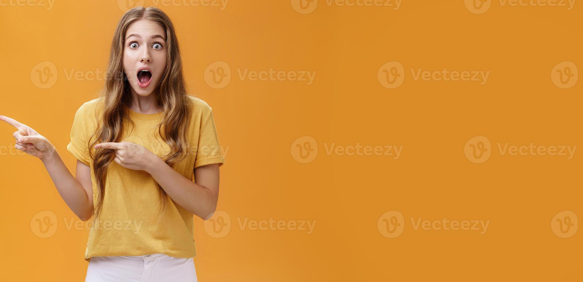 Just look at this prices. Portrait of shocked and amazed speechless cute beautiful woman with natural hairstyle and little scar on arm dropping jaw from amazement pointing left amused and excited photo