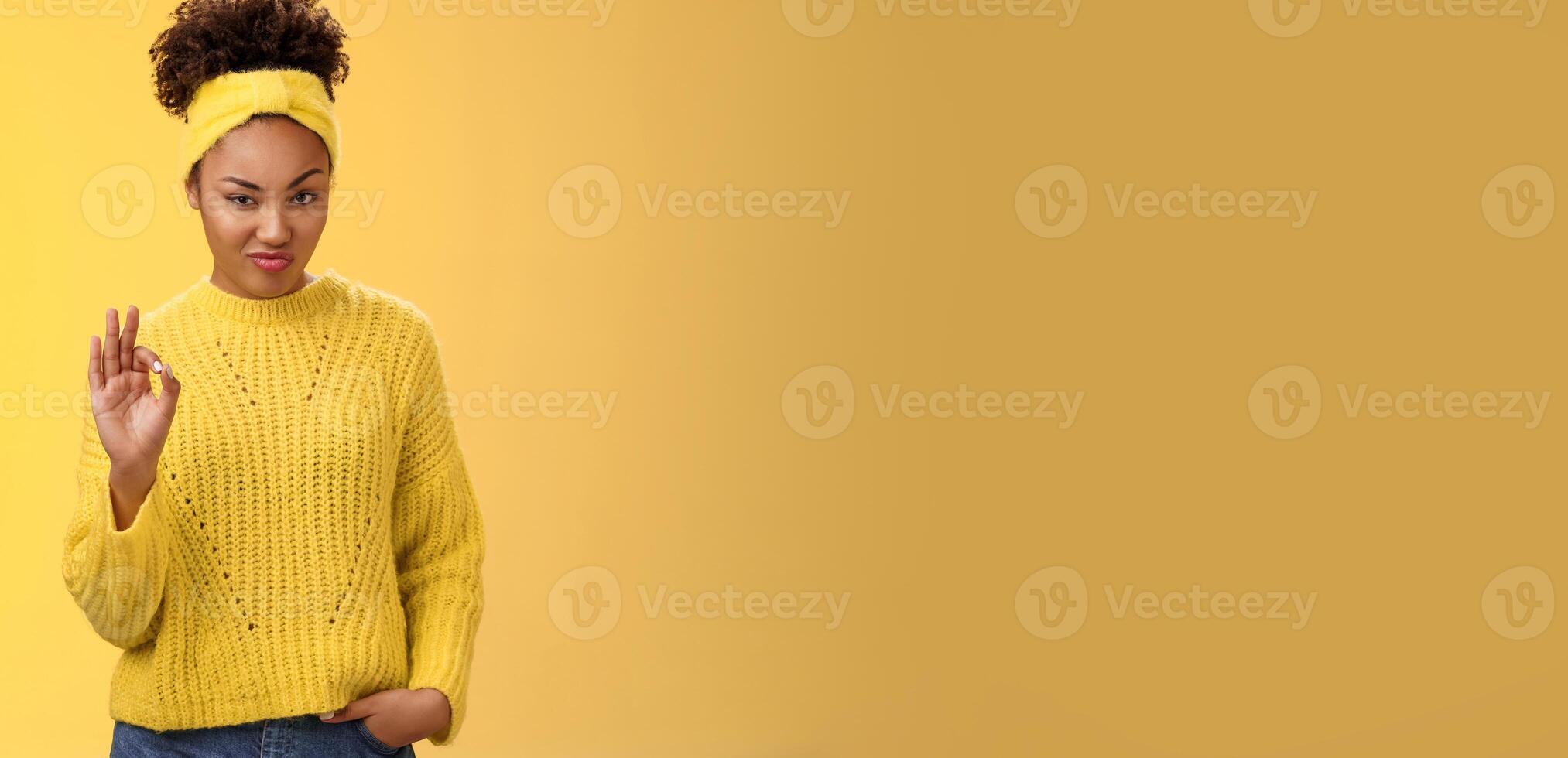 Okay not bad. Portrait devious serious-looking confident african-american bossy girl check out nice work done show ok gesture smug approval agree like good job, standing yellow background pleased photo