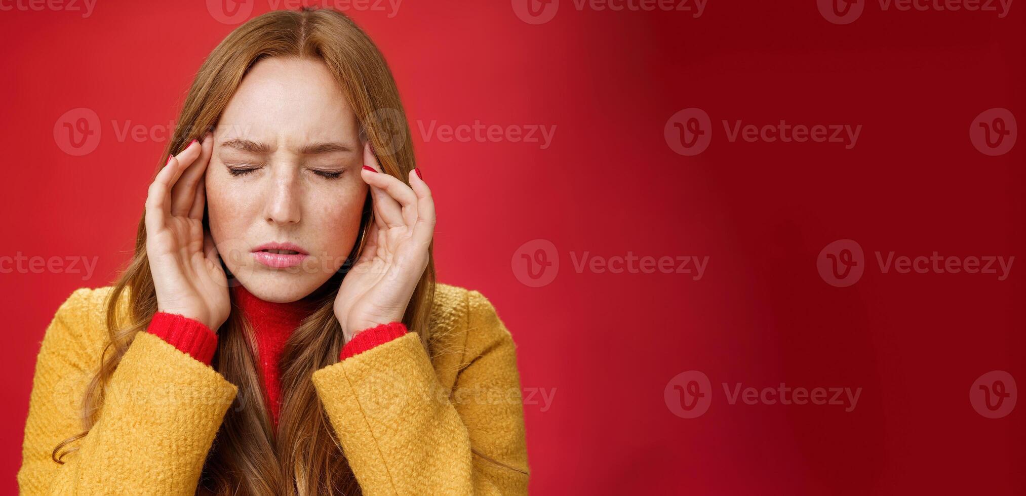Girl trying keep thoughts together feeling tensed and pressured close eyes frowning rubbing temples, feeling headache or migraine, focusing on thoughts over red background photo