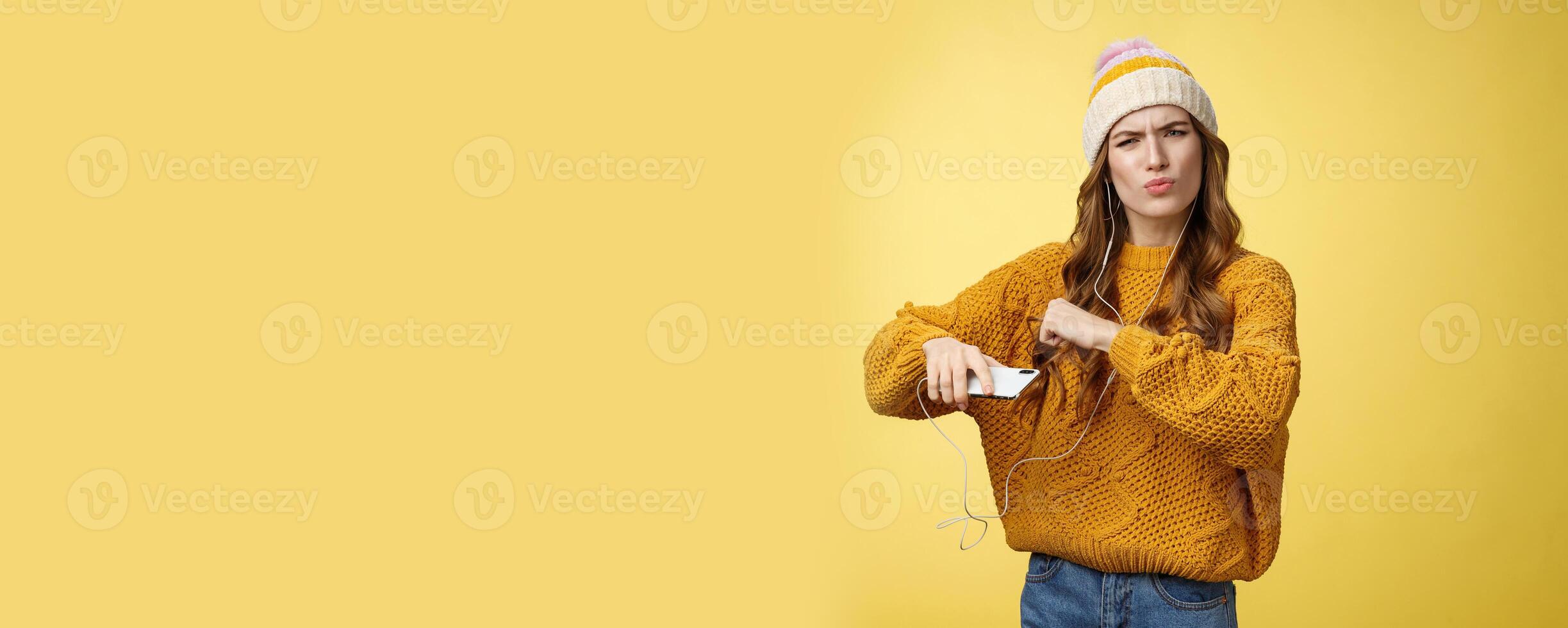 Shake your body. Portrait cool amused good-looking stylish girlfriend listen music via wired earphones dancing moving hands rhythm cool song holding smartphone folding lips frowning satisfied photo
