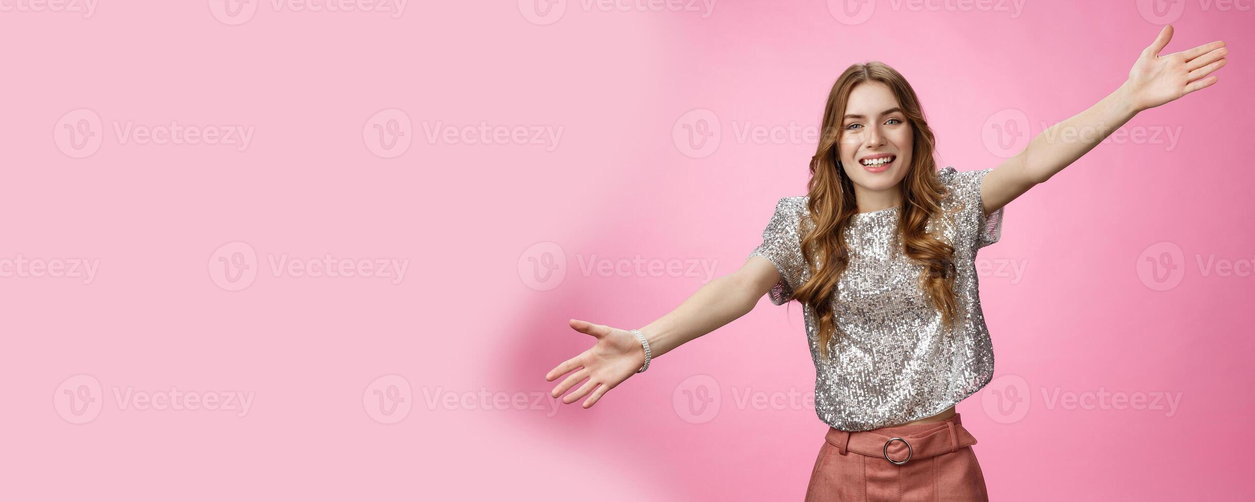 Come into my arms. Portrait friendly outgoing charming cute caucasian female wearing glittering blouse extend arms sideways wanna embrace cuddle friend welcoming hugging guests, smiling broadly photo