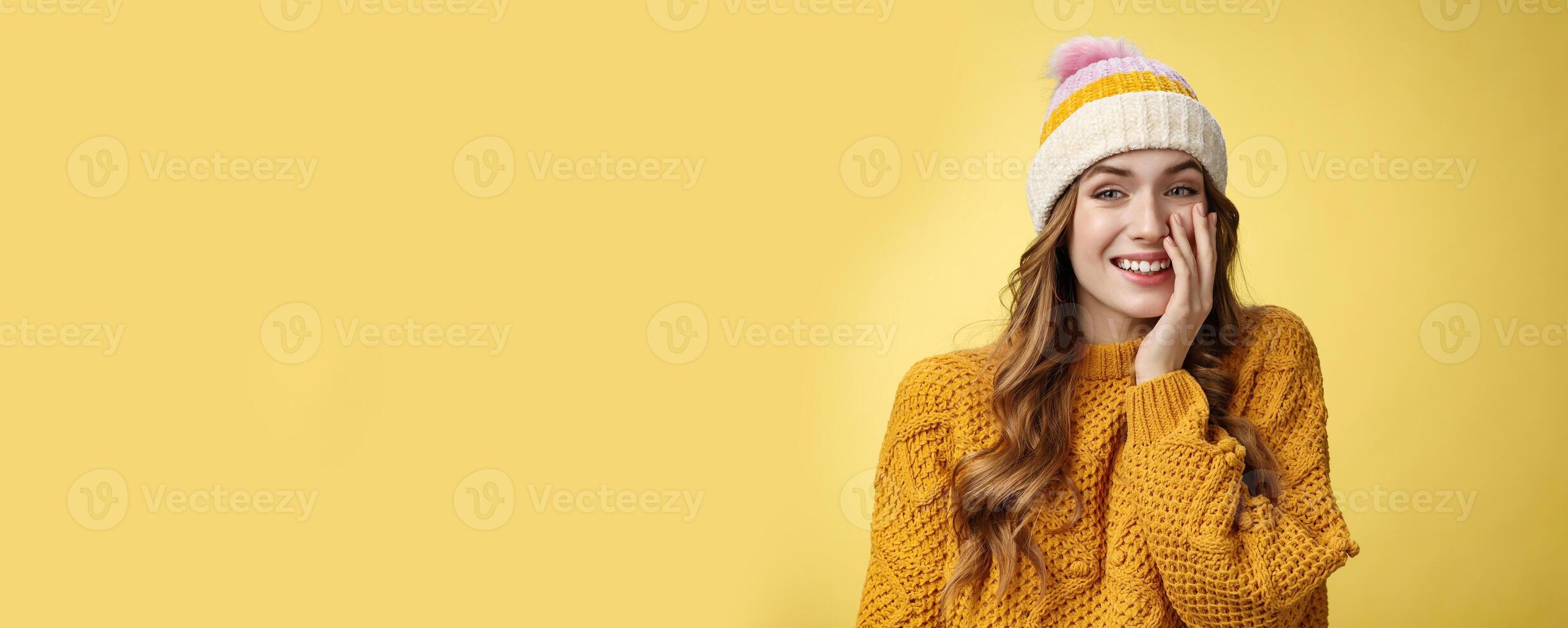 Smiling attractive carefree young 20s woman having fun talking casually nice conversation girlfriend press palm cheek amused blushing receive flirty compliment, standing positive yellow background photo