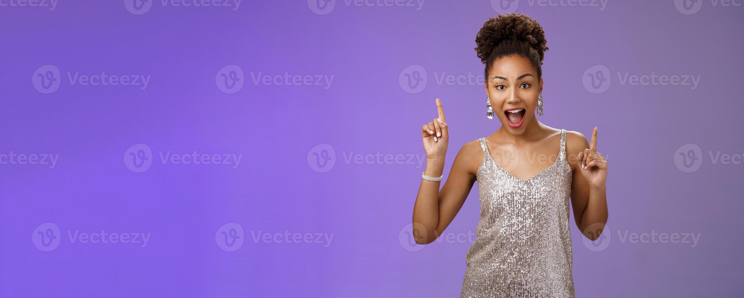 Lucky beautiful african american woman having fun dancing celebrating good news pointing index fingers up astonished smiling delighted rejoicing partying, triumphing do winner dance photo