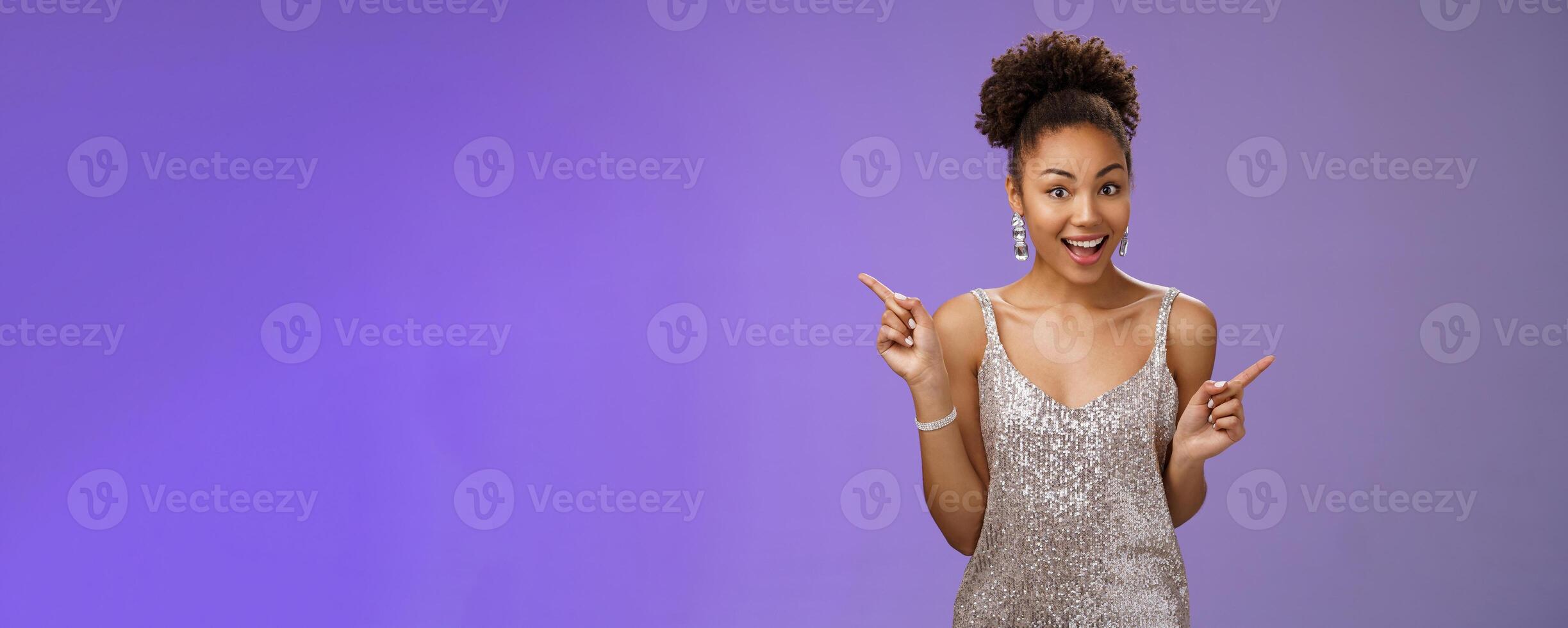 Charming outgoing african-american party girl have fun dancing pointing different sides right left show choices variants smiling broadly asking advice which way go, standing blue background photo